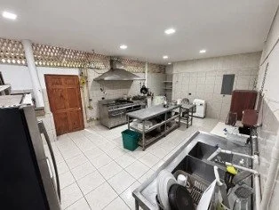 Commercial restaurant kitchen with stainless steel preparation tables and cooking equipment in Tambor, Costa Rica.