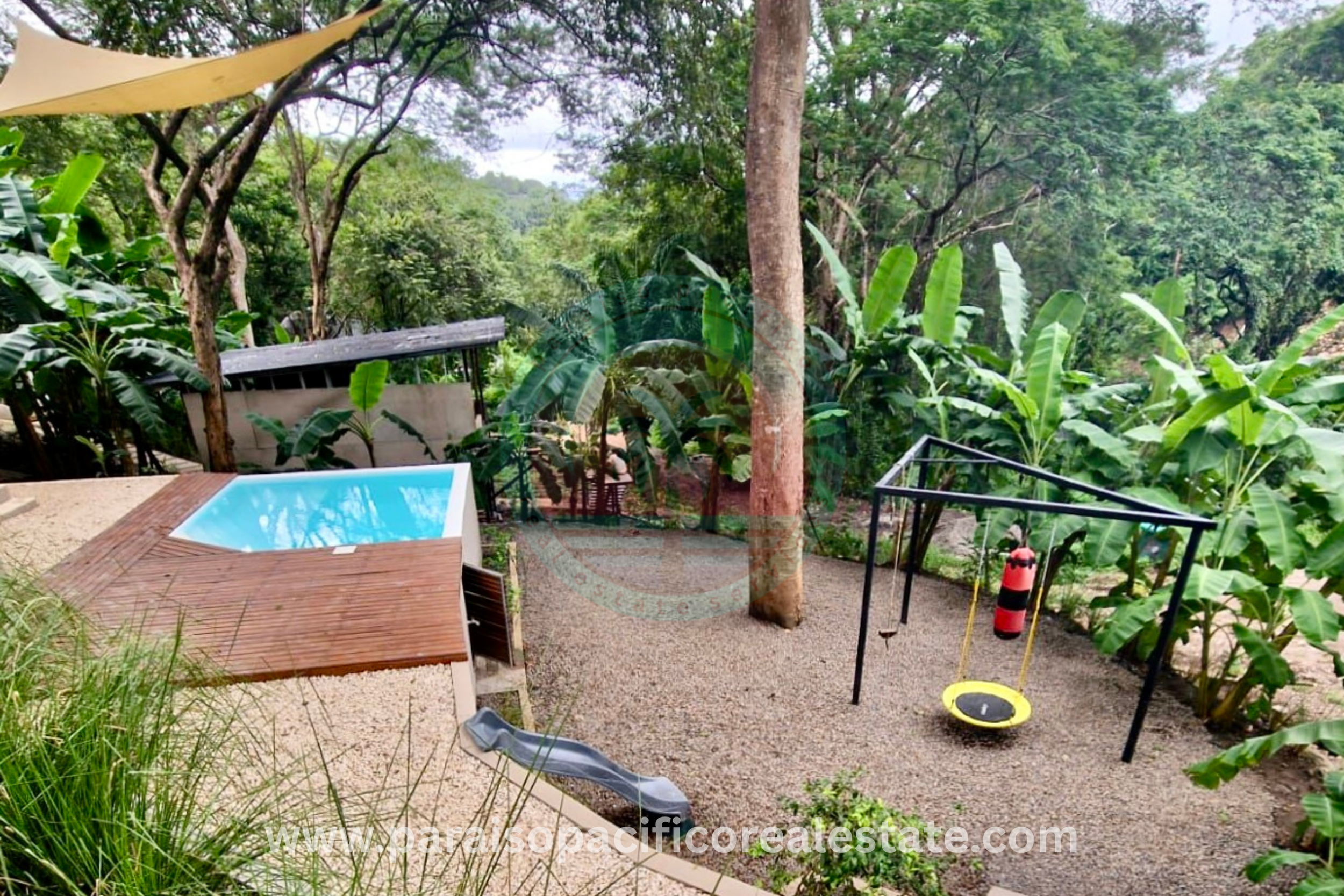 Exterior garden with pool and playground at Buddha House Organos near the beach in Costa Rica