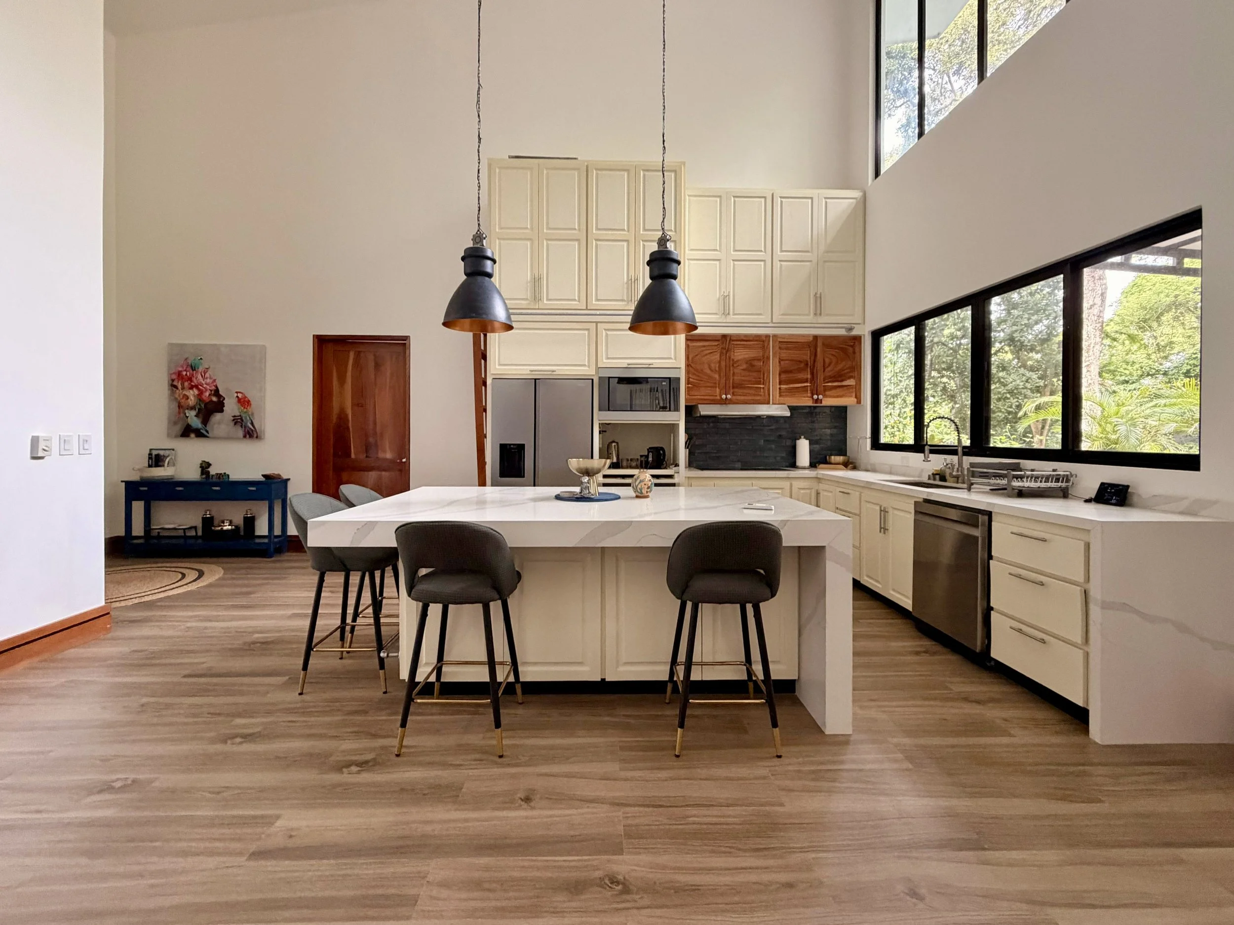 Casa Quantum luxury kitchen with spacious island, pendant lighting and contemporary white cabinetry.