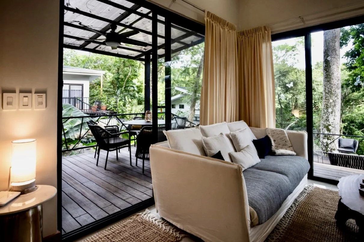 Inviting living room opening onto a covered outdoor terrace with tropical garden views at House of Light near Playa Órganos, Costa Rica