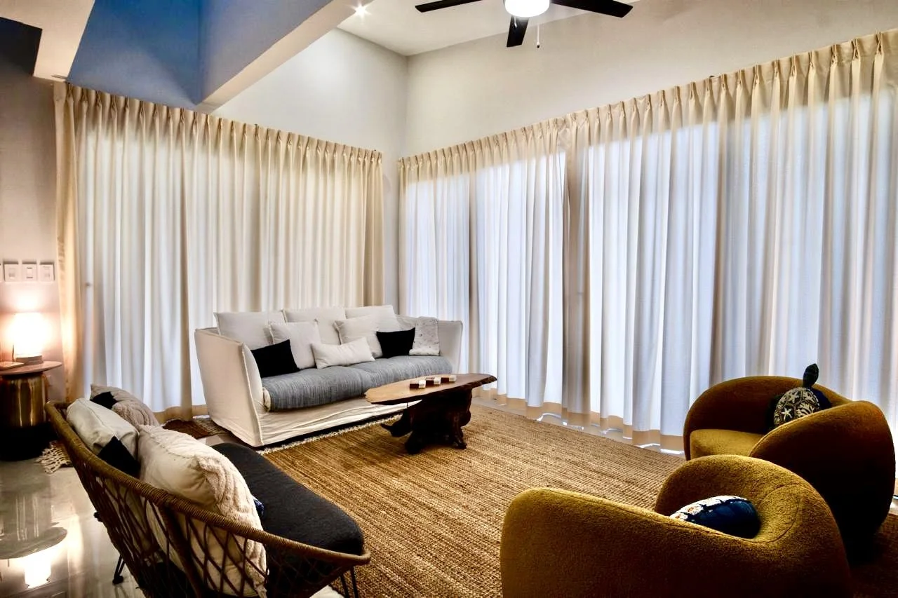 Comfortable furnished living room with elegant full-length curtains, spacious seating and natural light at House of Light in Paquera, Costa Rica