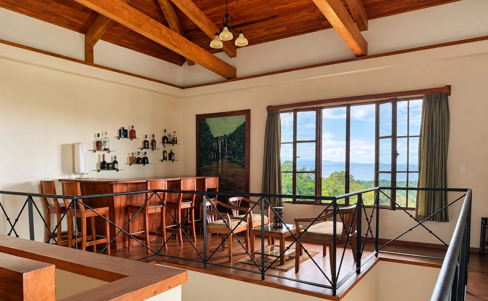 Upper-level entertainment space with bar, vaulted wood ceiling and scenic views at Finca Pamela