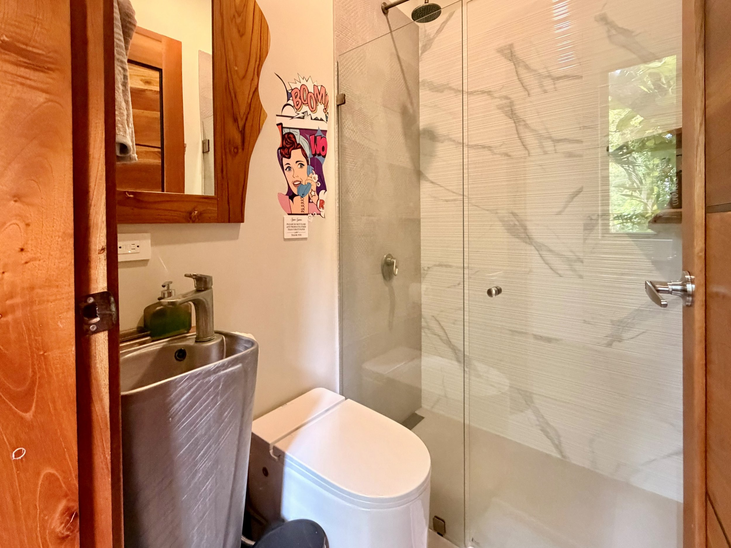 Casa Colina modern bathroom with glass-enclosed shower, vessel sink, wooden vanity and contemporary finishes.