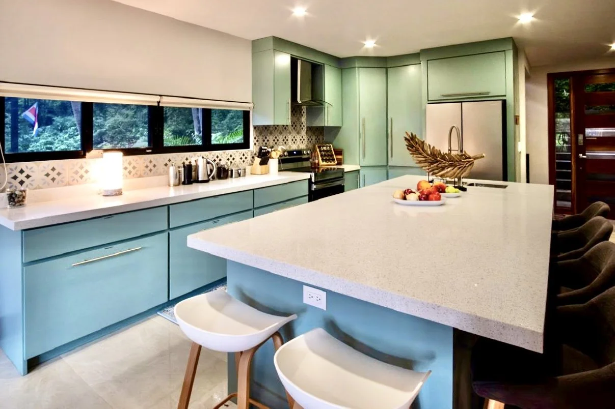 Open-concept designer kitchen with large quartz island, breakfast bar seating and custom cabinetry at House of Light in Paquera, Costa Rica