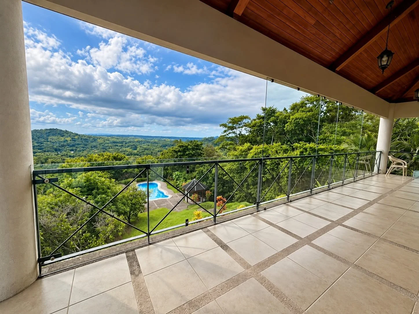 Covered terrace overlooking the swimming pool and lush tropical hills at Finca Pamela luxury estate in Tambor, Costa Rica.