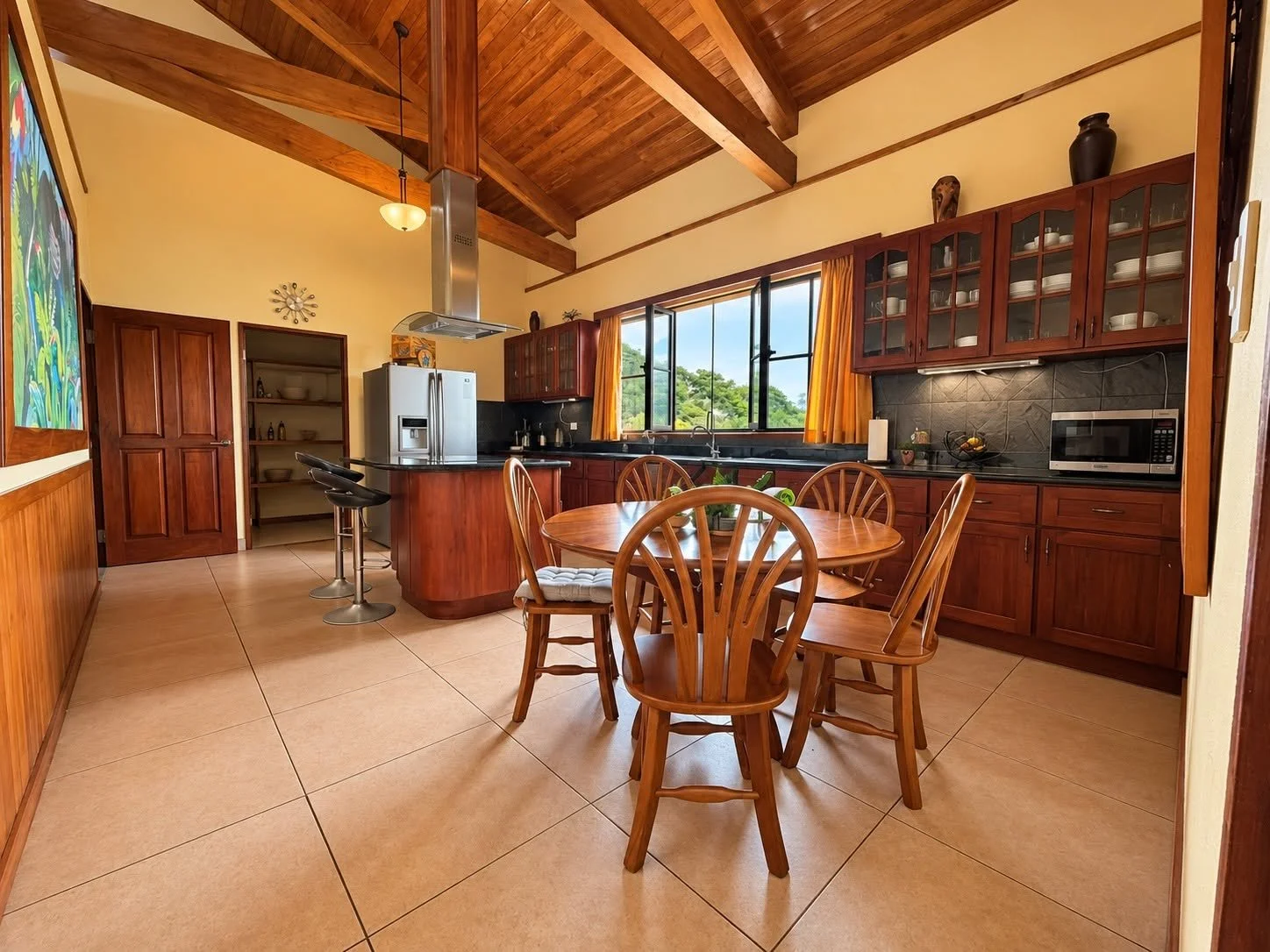 Open kitchen and dining area with wood cabinetry and high ceilings in Tambor luxury estate