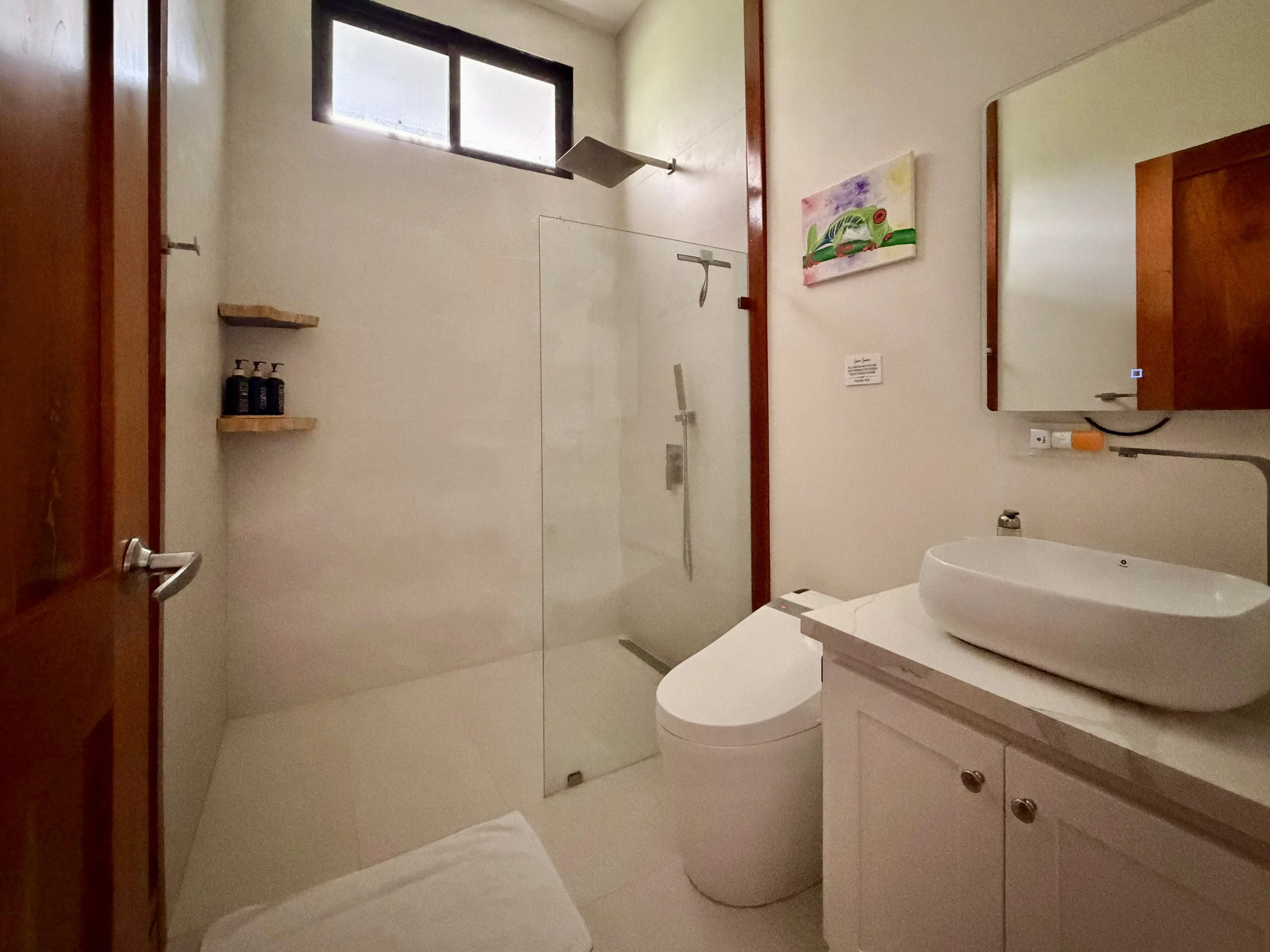 Casa Quantum modern bathroom with walk-in shower, glass partition, white vanity and contemporary fixtures.