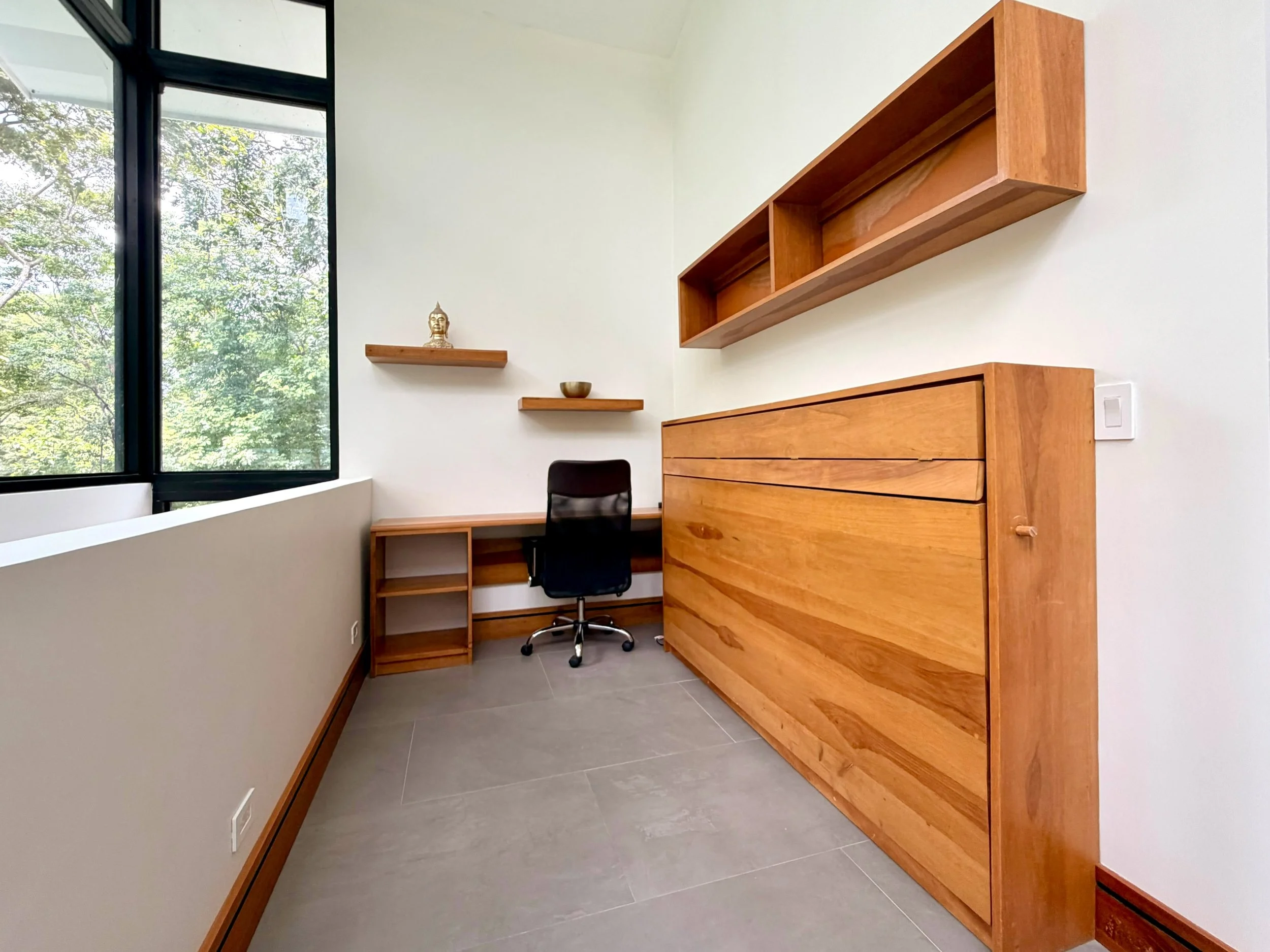 Casa Colina home office with built-in wooden wall bed, desk, shelving and natural light.