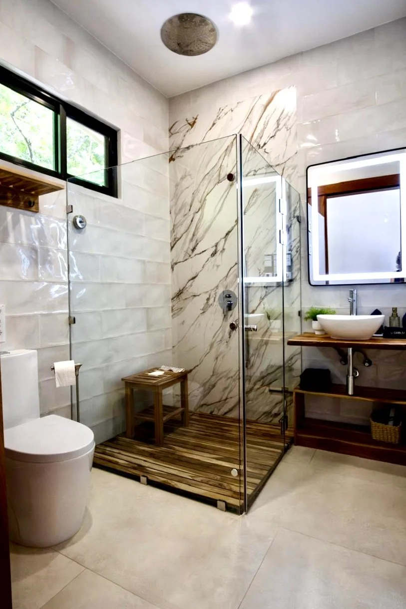 Modern bathroom with marble-look tiles, glass walk-in shower and contemporary vanity at House of Light in Paquera, Costa Rica