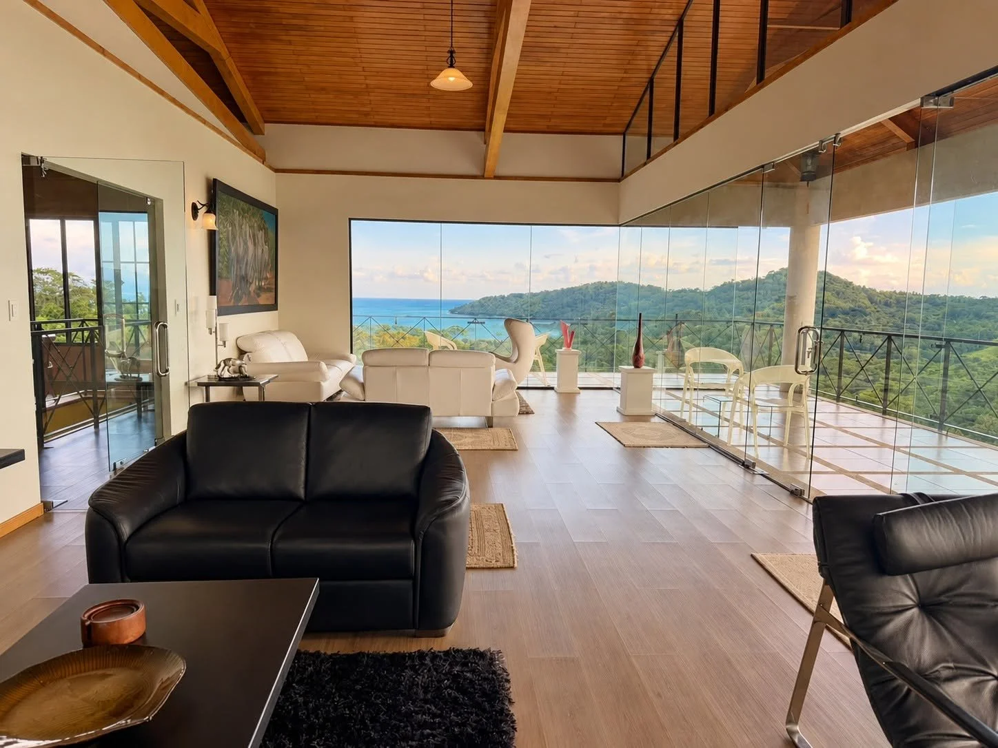 Spectacular glass-walled upper-level living room with panoramic Pacific Ocean views at Finca Pamela