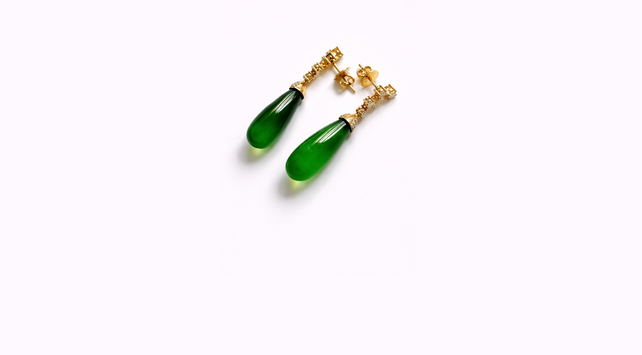Pair of gold earrings with green teardrop-shaped gemstones on a white background.