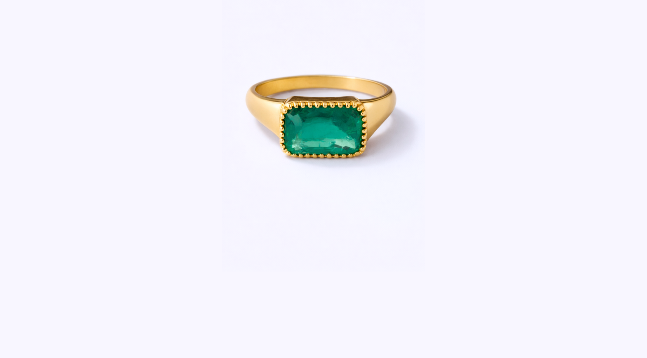 Gold ring with a large rectangular green gemstone in the center, against a plain white background.