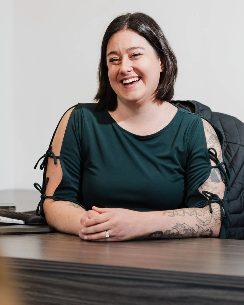 Cailin Jarrell is a smiling dark haired woman sitting at a desk in Vancouver, WA.