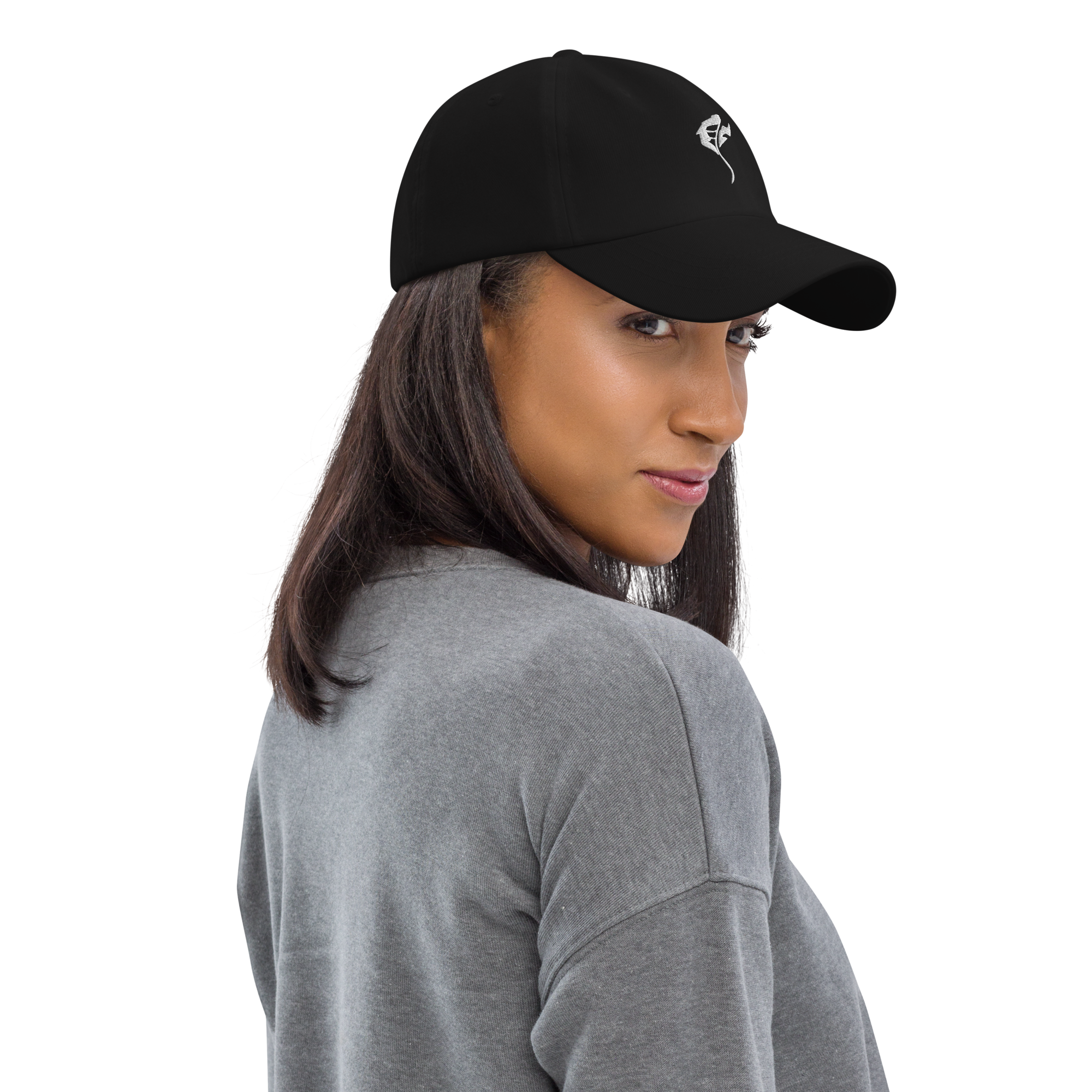 Close-up of a woman wearing a black cap with a white logo, gray sweater, and with long brown hair.