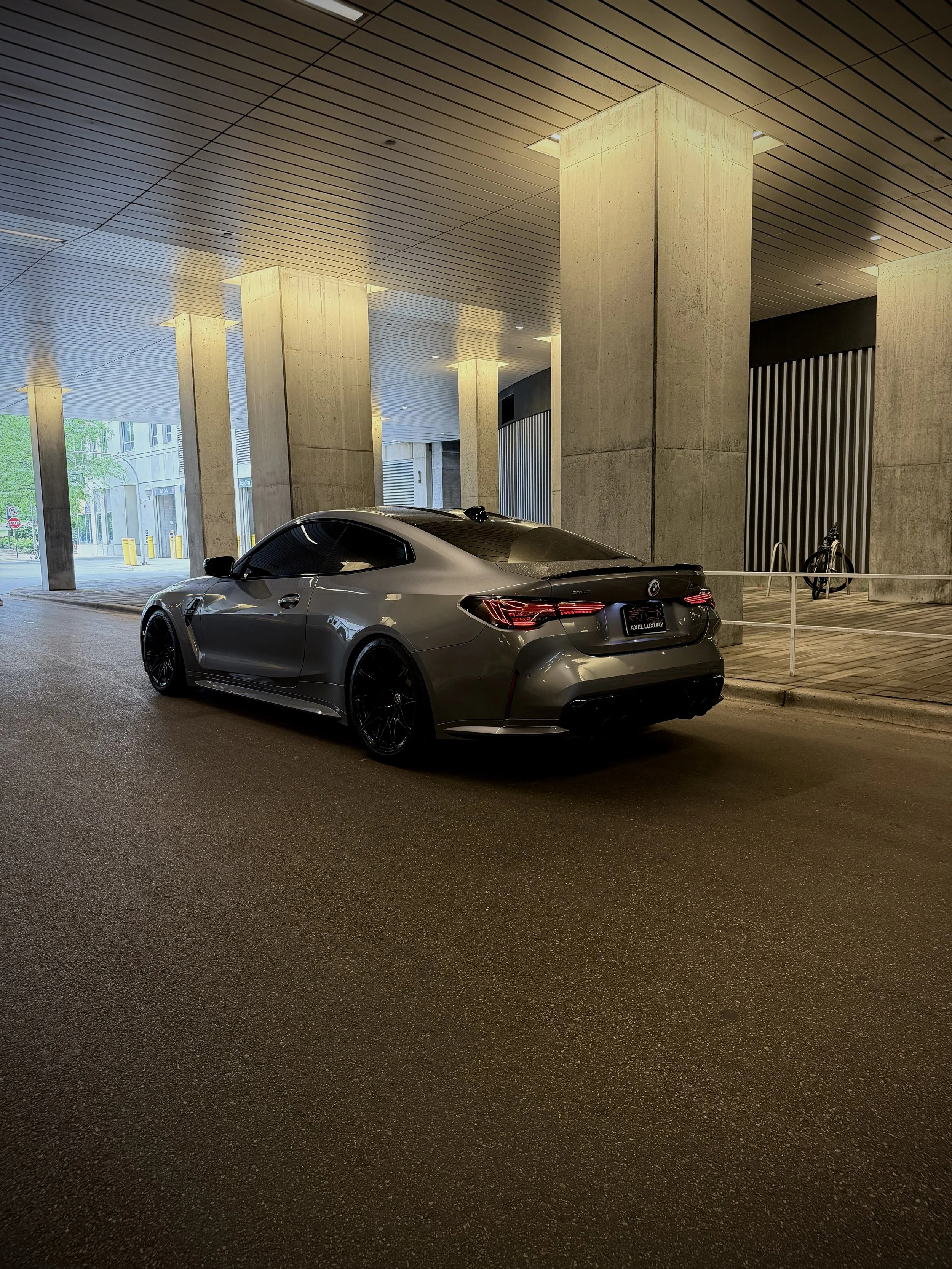 Metallic gray BMW M4 Competition parked in Chicago, featuring aggressive styling, black wheels, premium performance, and a twin-turbocharged engine available for luxury and exotic car rental.