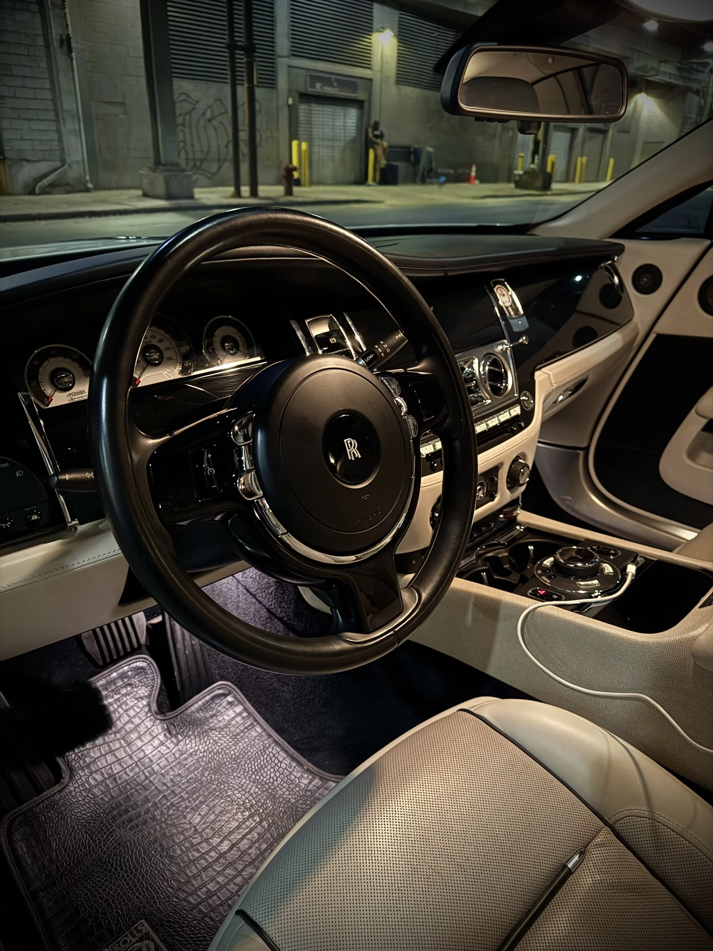 White Rolls-Royce Wraith rental from Axel Luxury parked in downtown Chicago with luxury white-on-white styling.