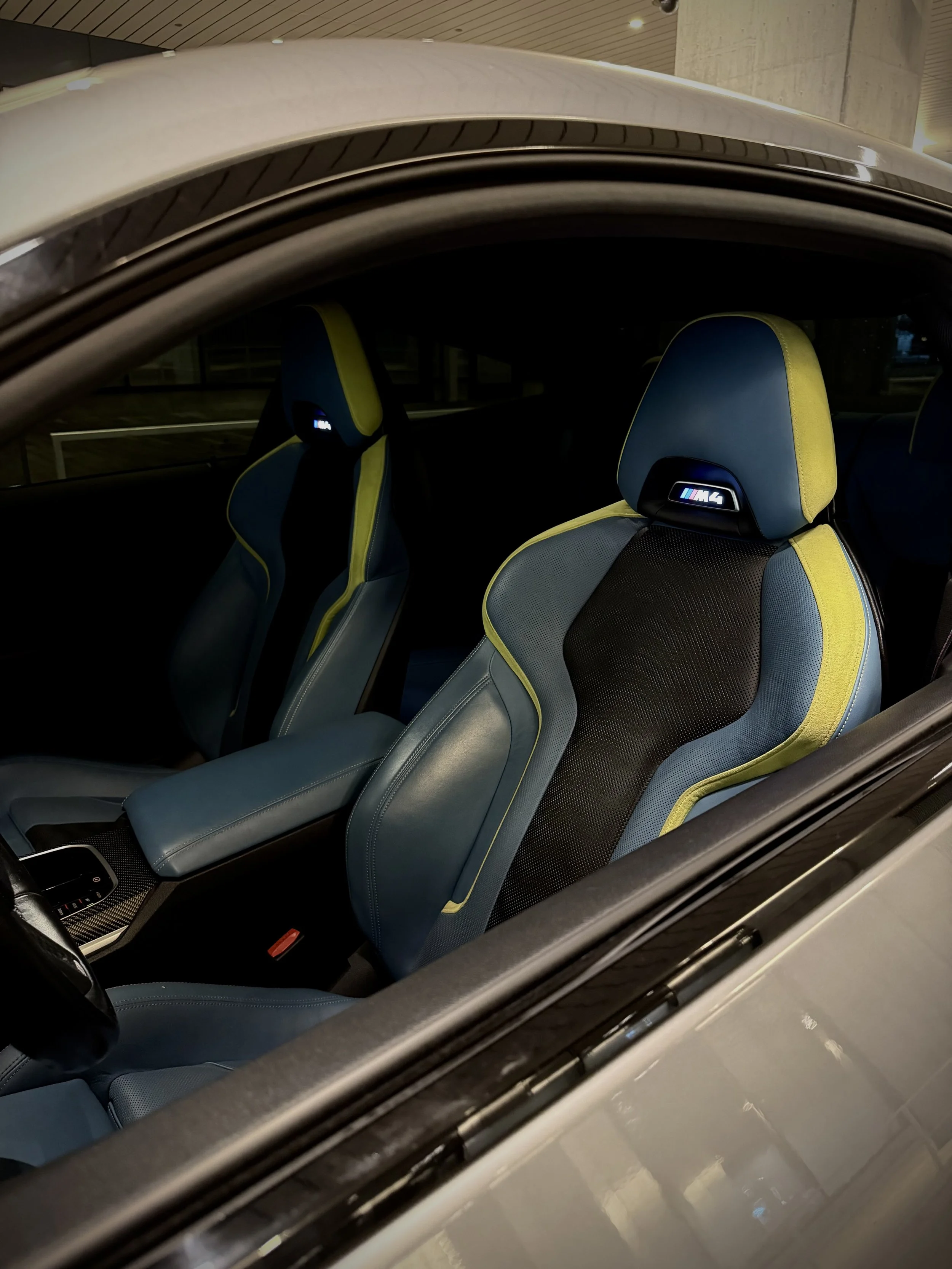 Metallic gray BMW M4 Competition parked in Chicago, featuring aggressive styling, black wheels, premium performance, and a twin-turbocharged engine available for luxury and exotic car rental.