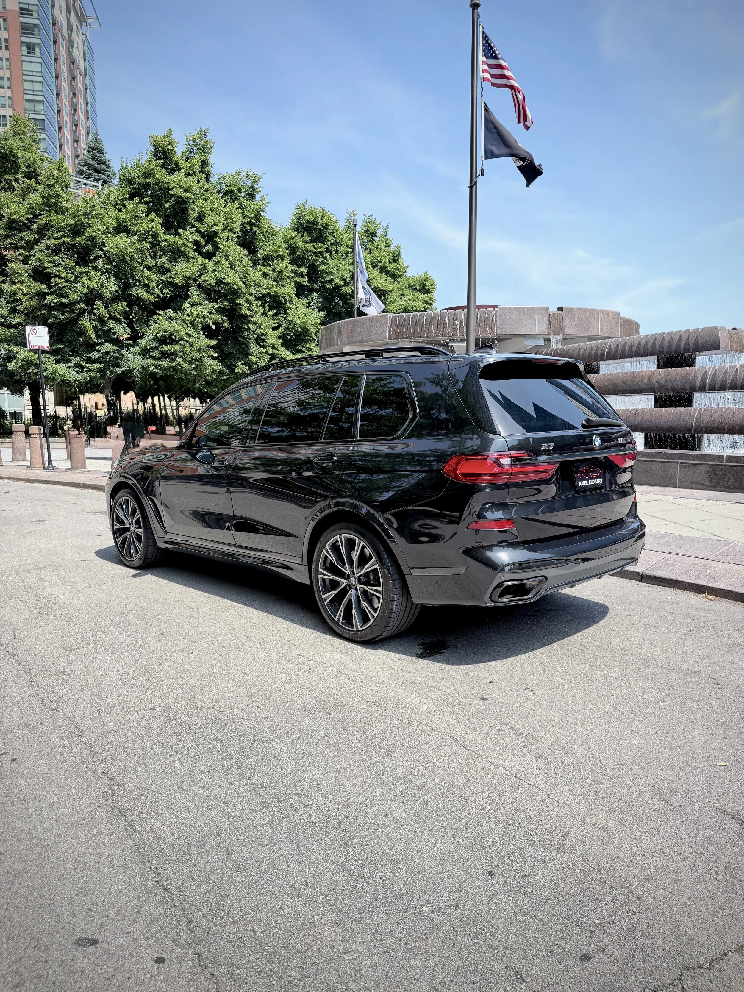 Gloss Black BMW X7 M50i luxury SUV with rear entertainment screens available for rental in Chicago.