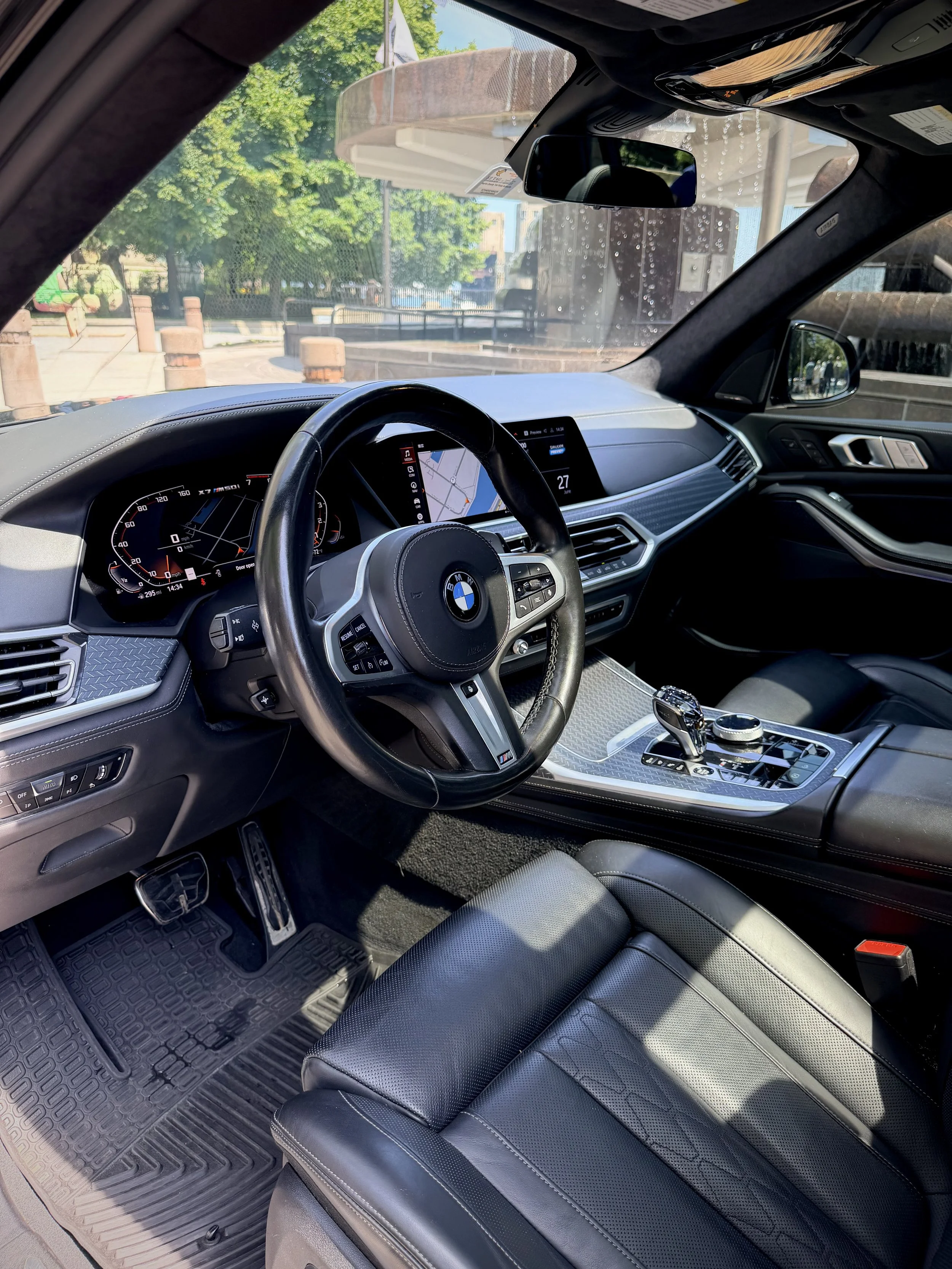 Gloss Black BMW X7 M50i luxury SUV with rear entertainment screens available for rental in Chicago.