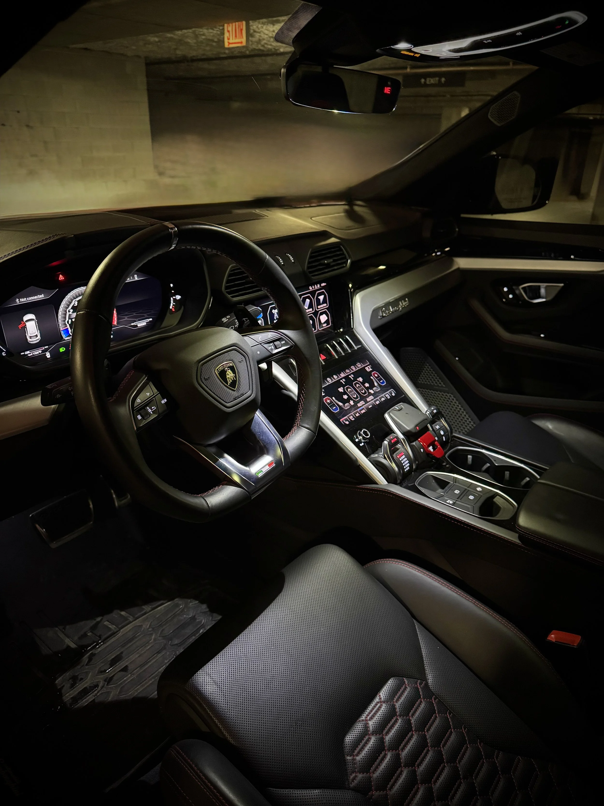Red Lamborghini Urus parked in an urban luxury setting