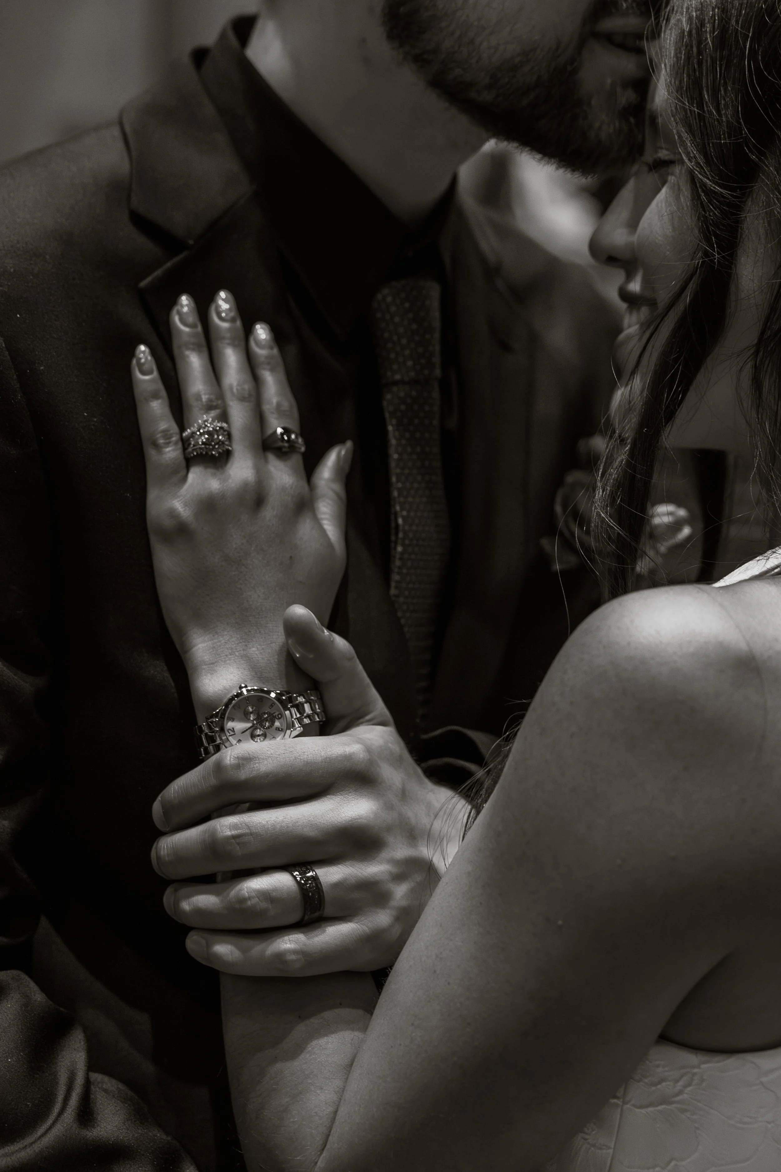Black and white wedding photography detail of a bride and groom embracing, showing wedding rings and hands during an intimate moment, captured by a Florence, KY wedding photographer.
