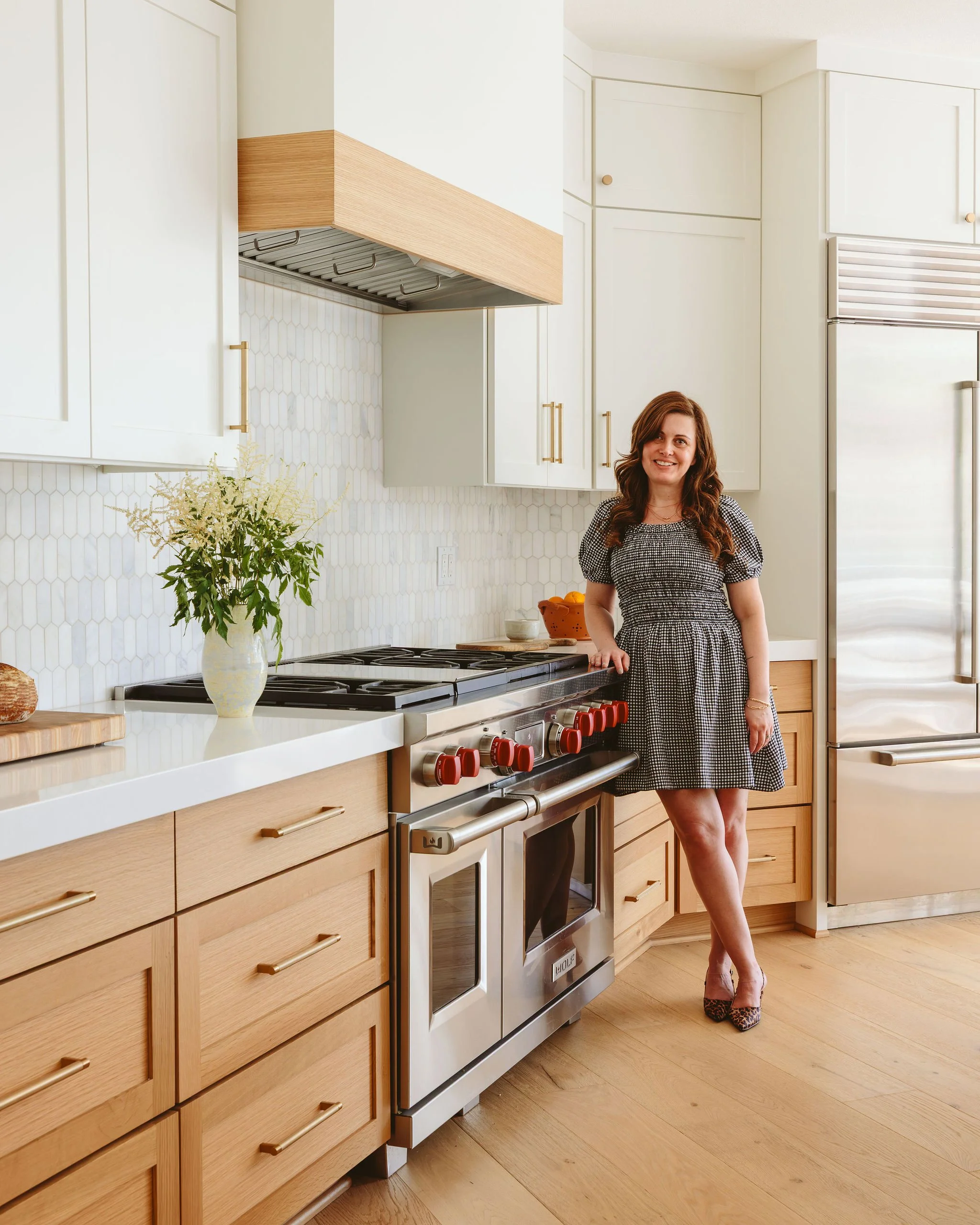 Interior Designer, Alana Spears, standing in a modern kitchen she designed.
