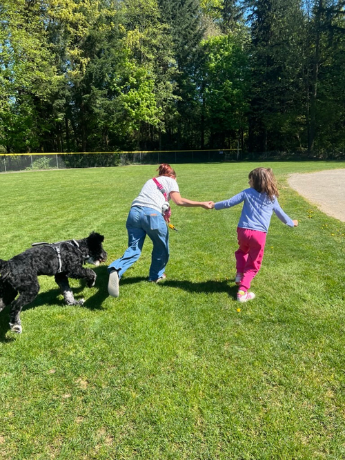 Children and adults playing together with a colorful parachute