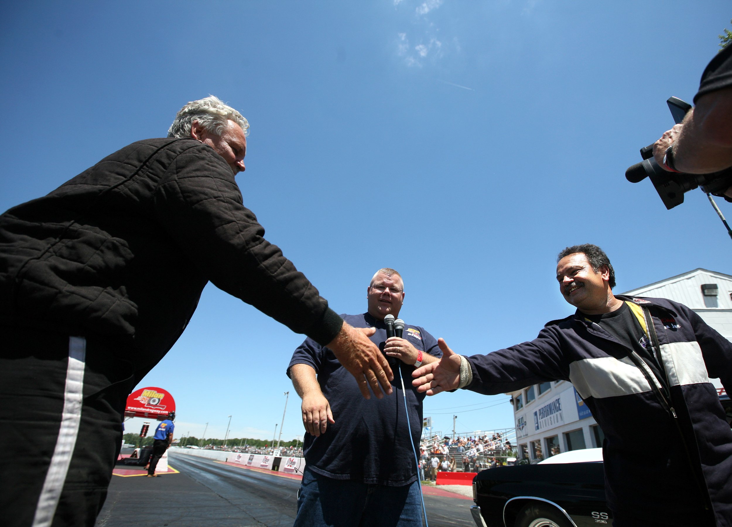 Steve Benedict, of Brownstown, left and Joe Fenech, of Allan Park shake hands as Mark Johnson, announcer and racer, readies them for a grudge match at the Milan Dragway in Milan Friday, July 04, 2008.