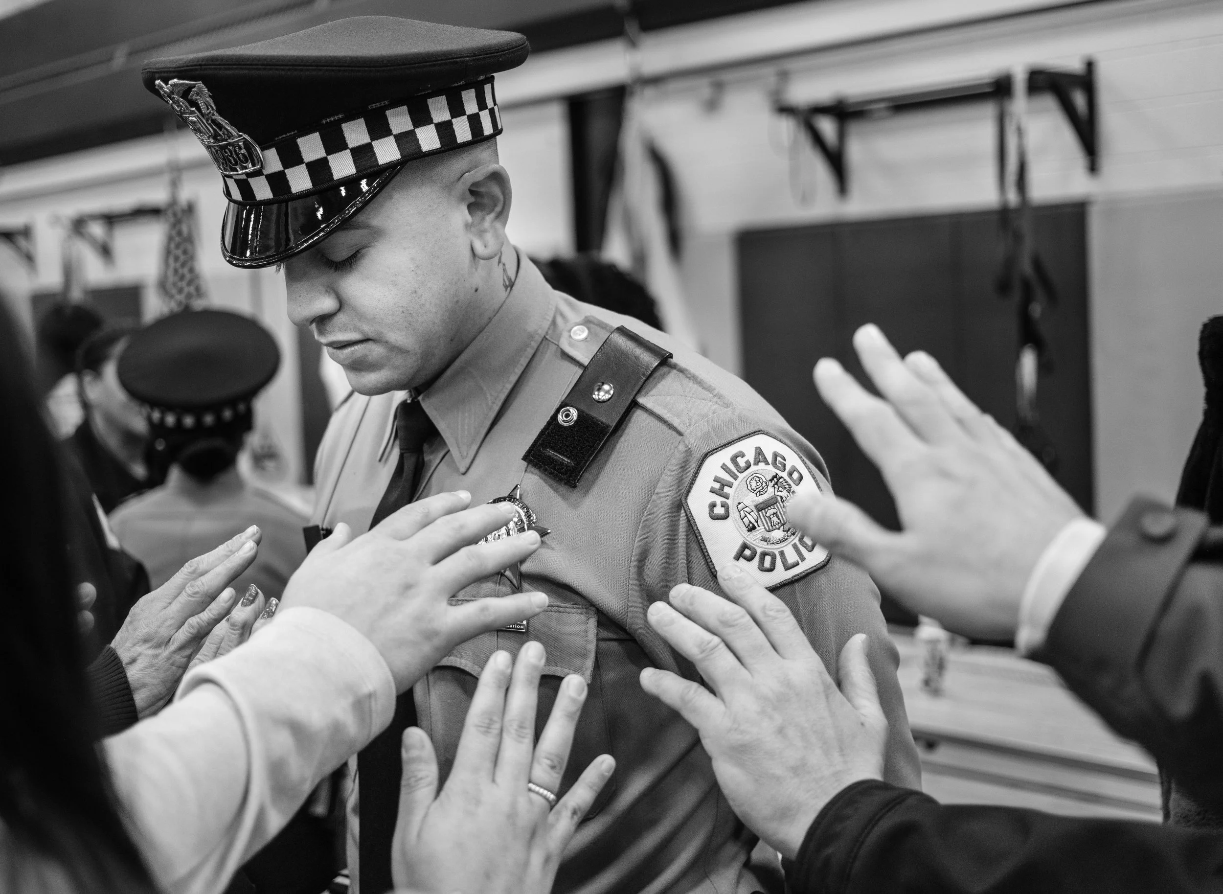 Family surround a newly sworn police officer with prayers and well wishes before he hits the street for the first time since completing six months of intense training at the Chicago Police Training Academy in Chicago. 