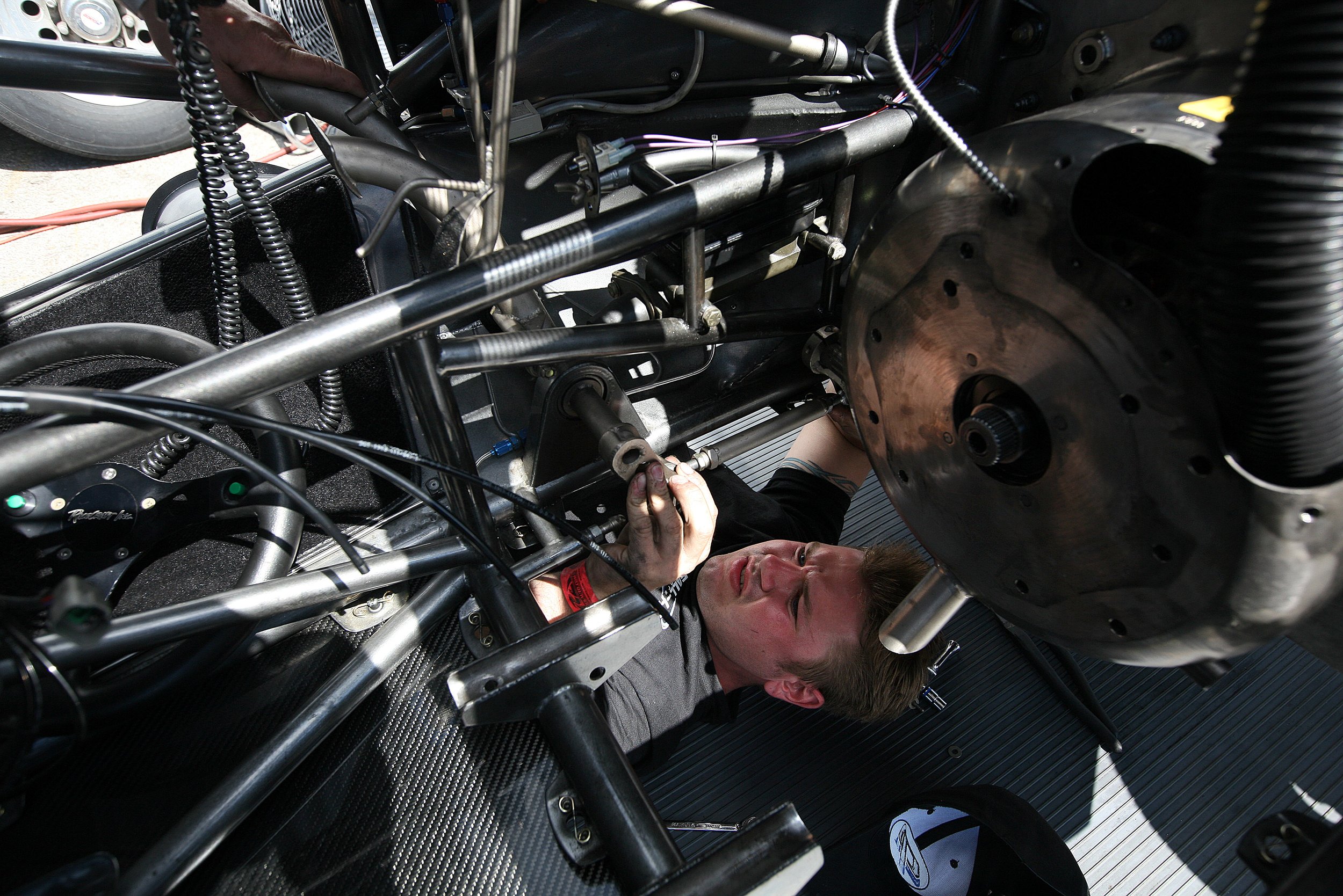 Mike Gawinski, 25, of AES racing from Elk Grove, IL, gets under the hood and repairs a funny car before the semi final races at the Milan Dragway in Milan Friday, July 04, 2008.