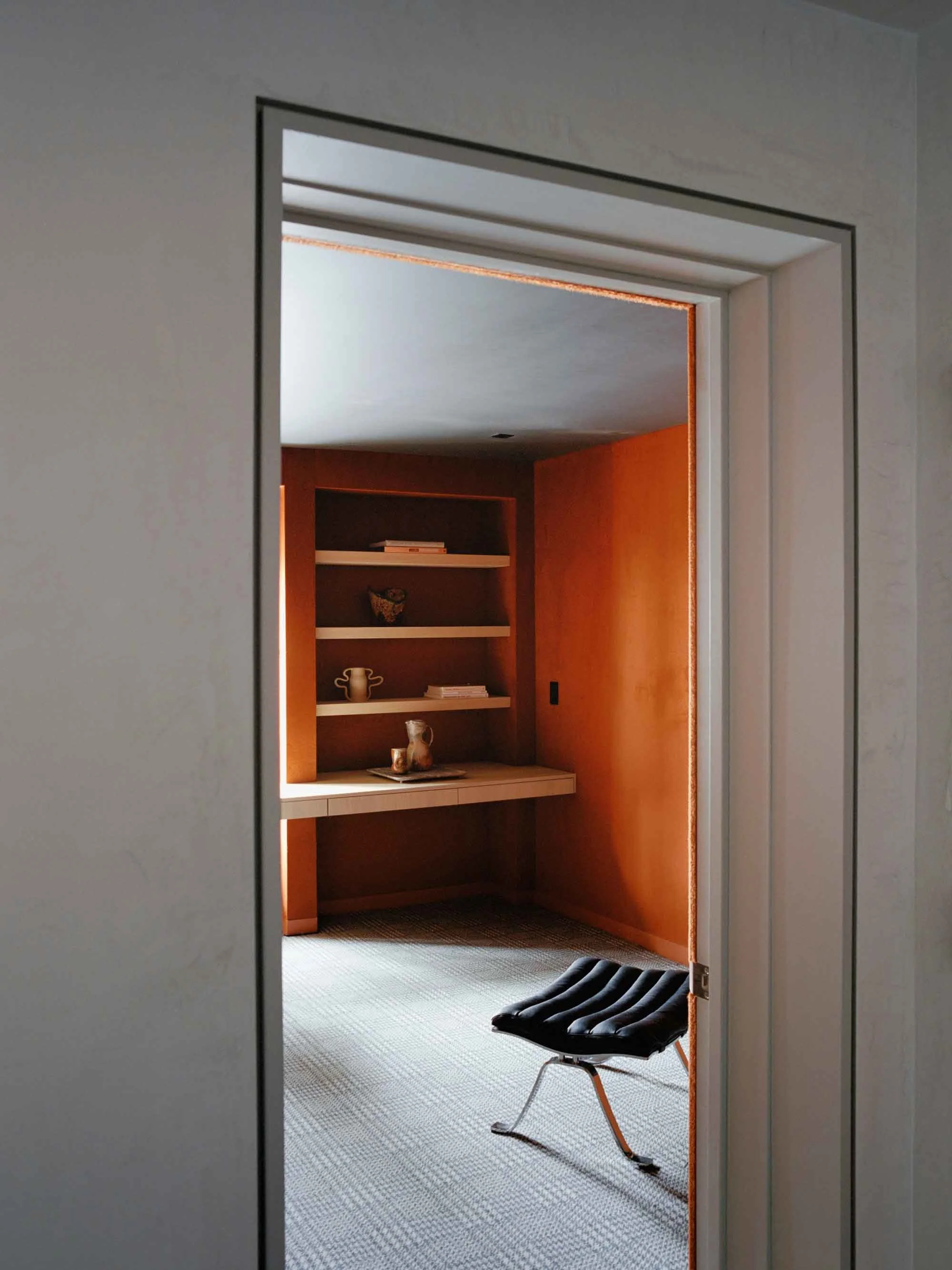 Minimal home office with bold, warm tones and natural light