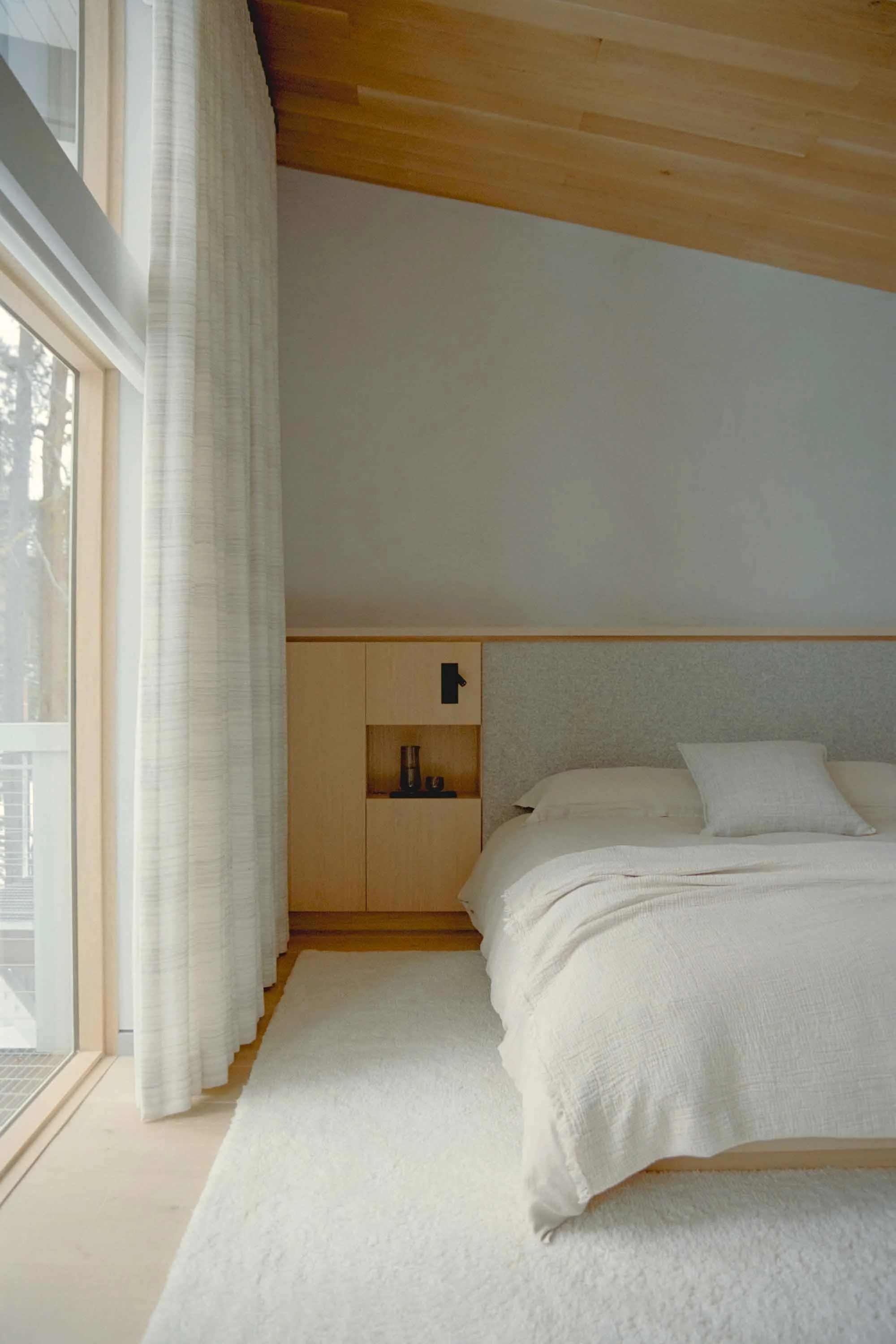 Serene mountain bedroom with soft neutral palette, cozy textiles, and warm wood accents inspired by Swiss chalet design