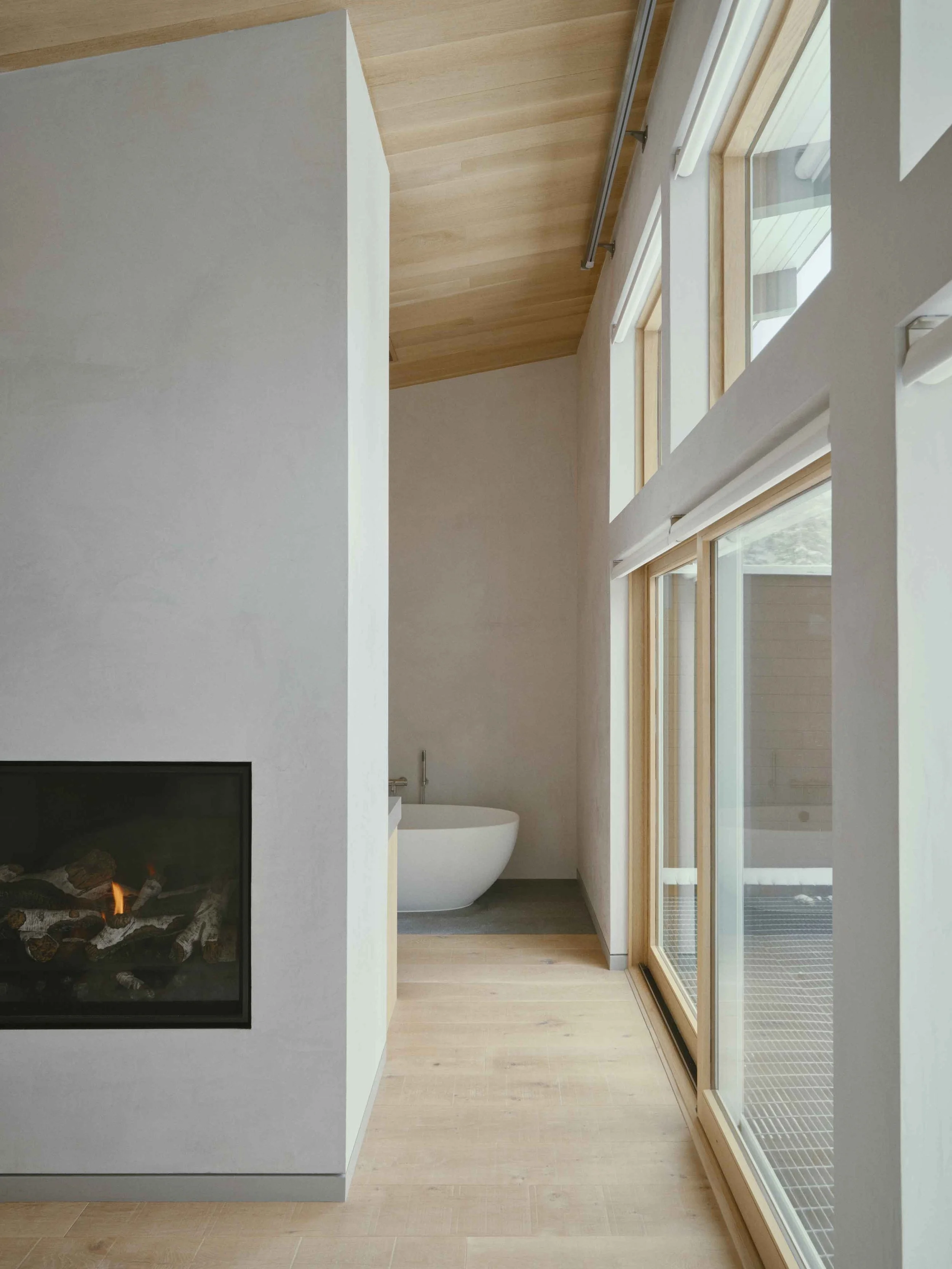 Spa-like primary bathroom with natural stone, soft lighting, and warm textures inspired by a luxury alpine retreat