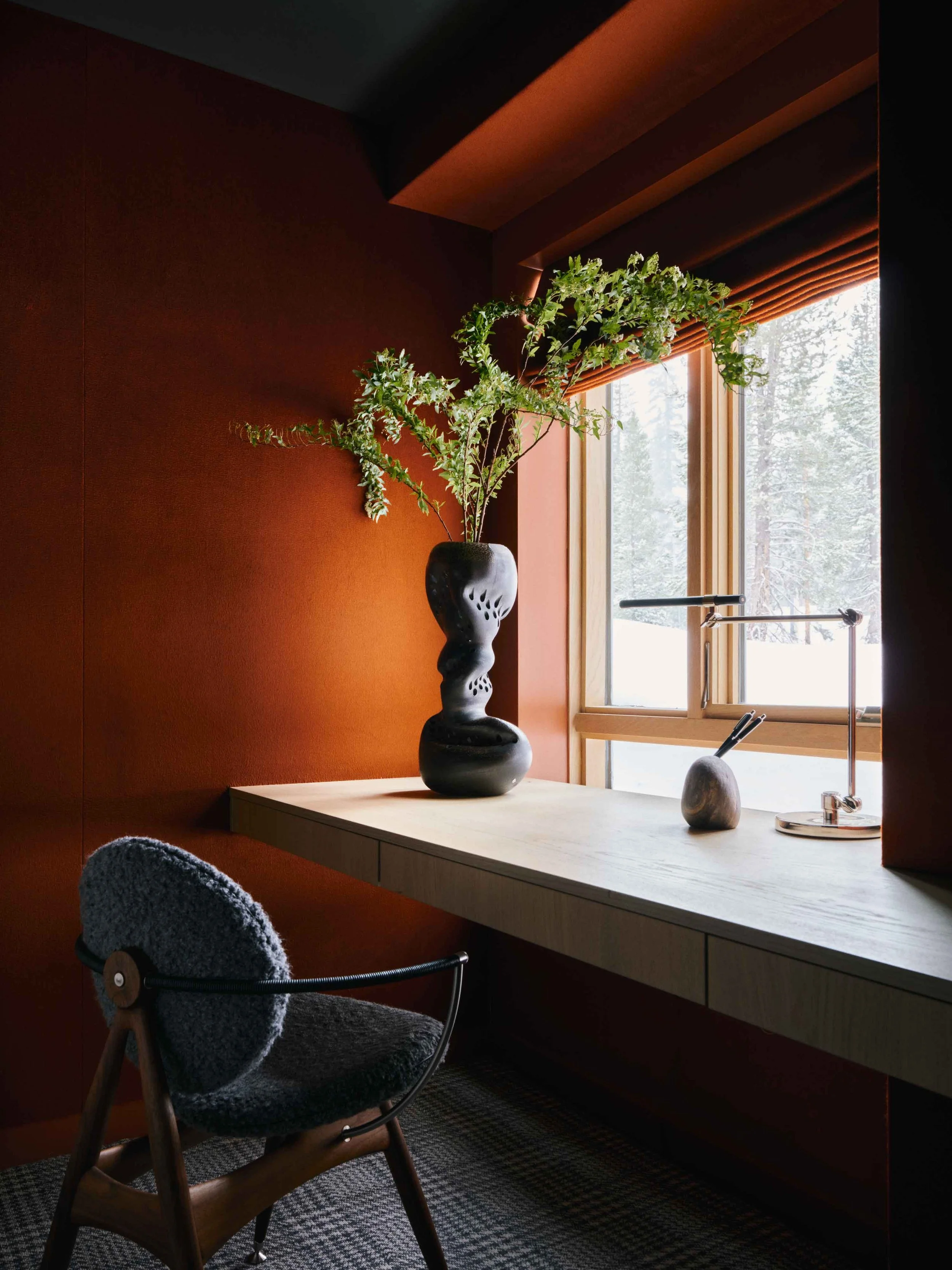 Minimal home office with bold, warm tones and natural light