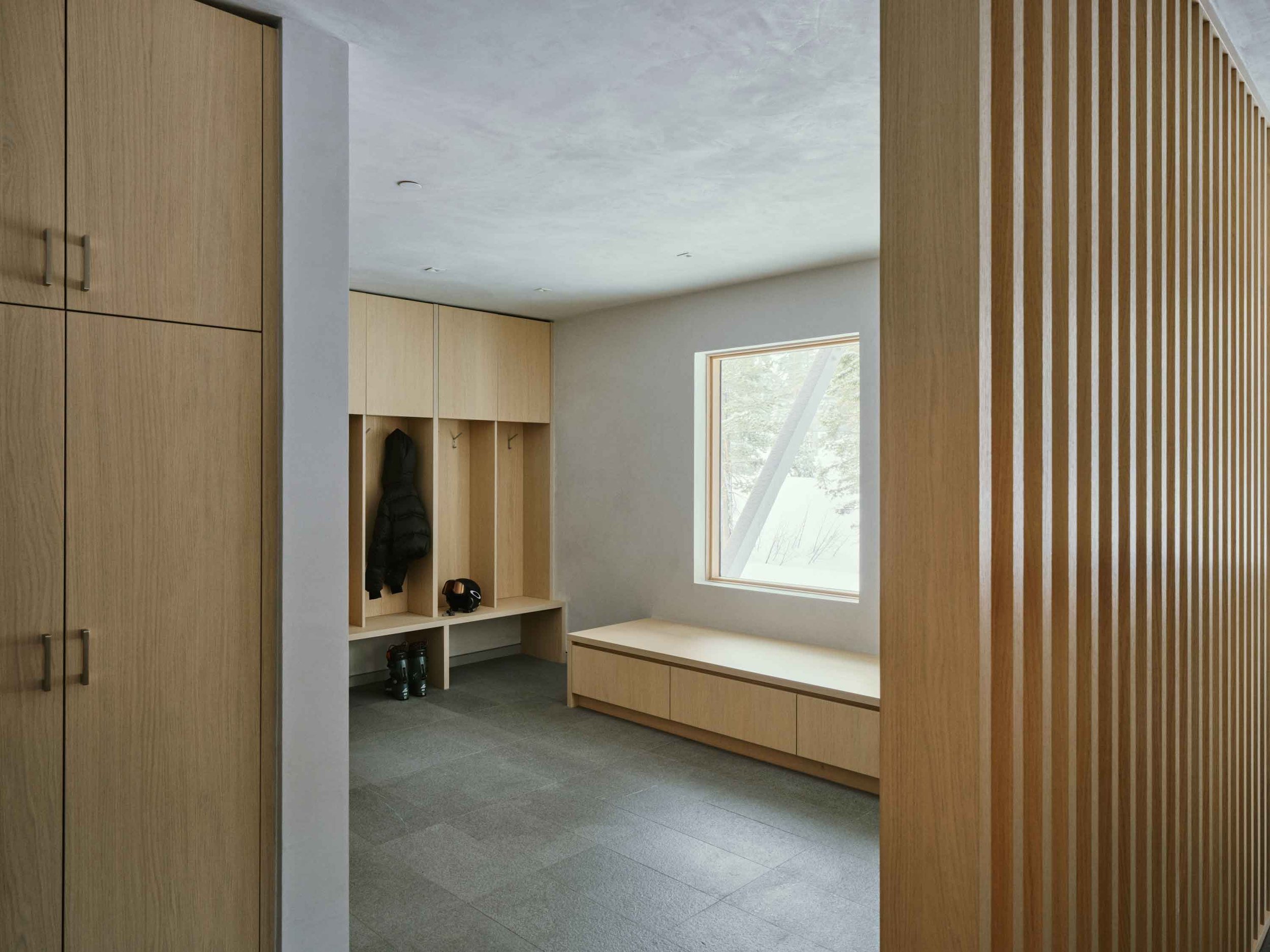 Welcoming mountain home foyer with natural materials, clean lines, and warm minimalist design influenced by European alpine style