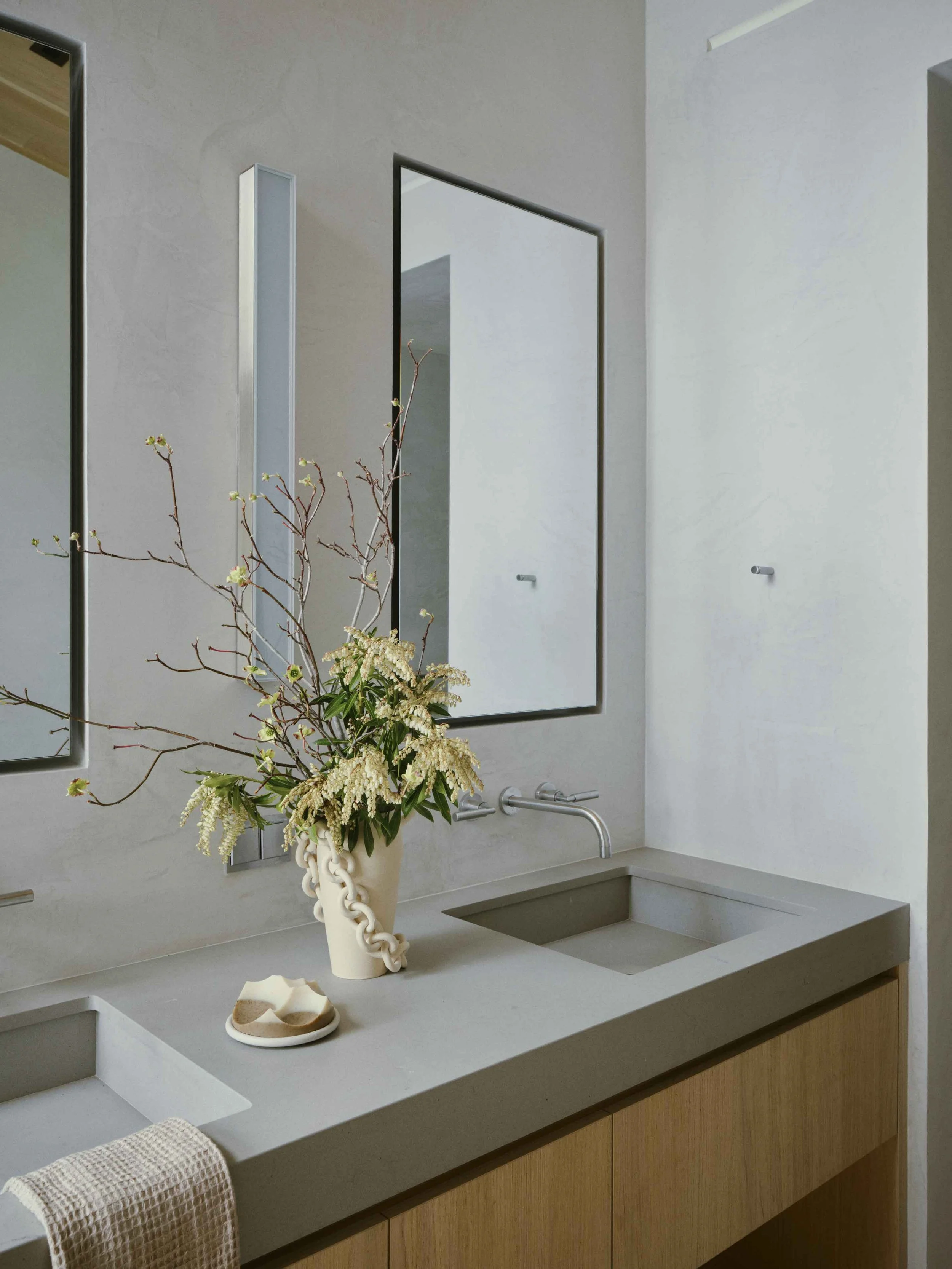 Spa-like primary bathroom with natural stone, soft lighting, and warm textures inspired by a luxury alpine retreat