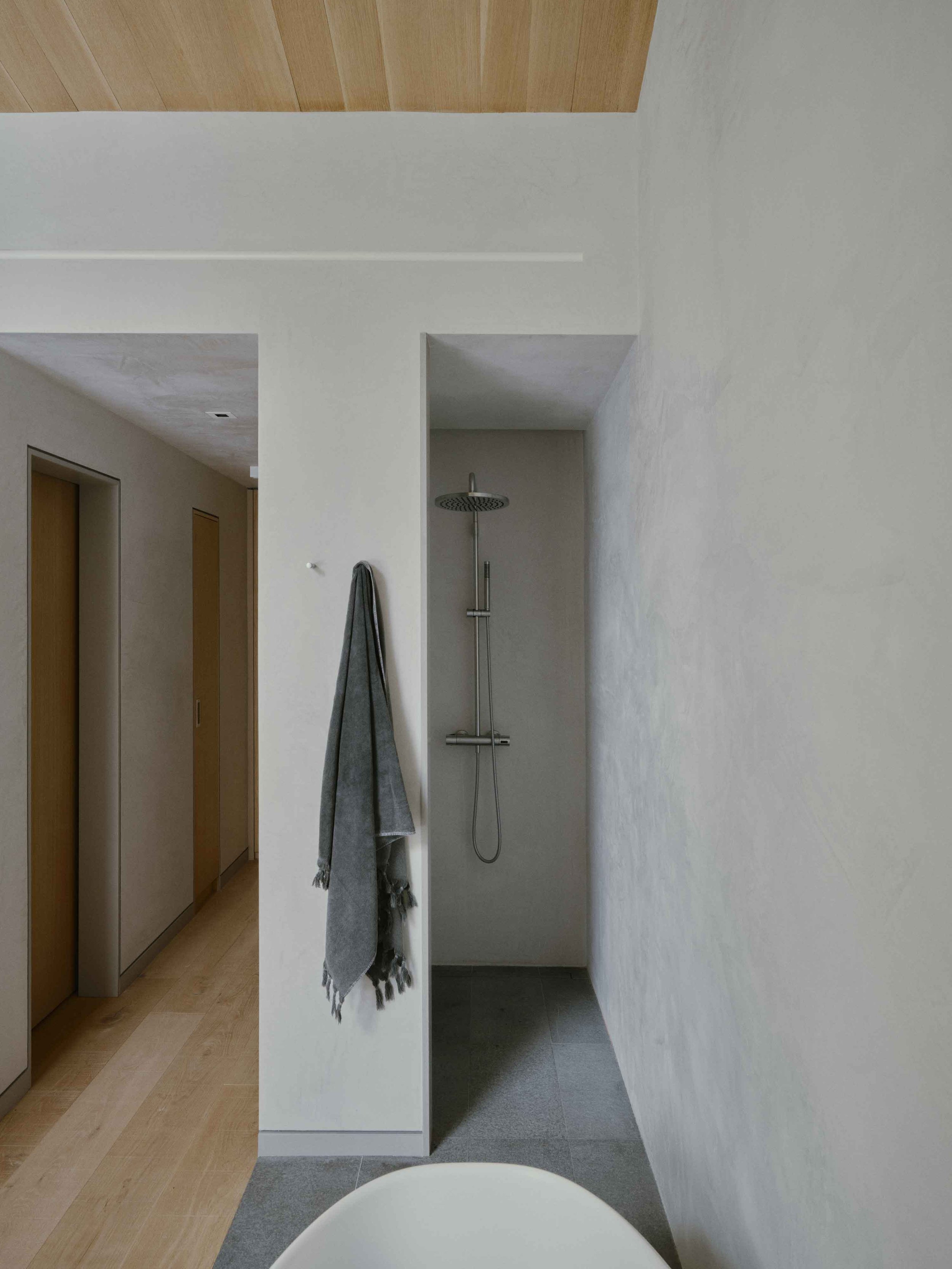Spa-like primary bathroom with natural stone, soft lighting, and warm textures inspired by a luxury alpine retreat