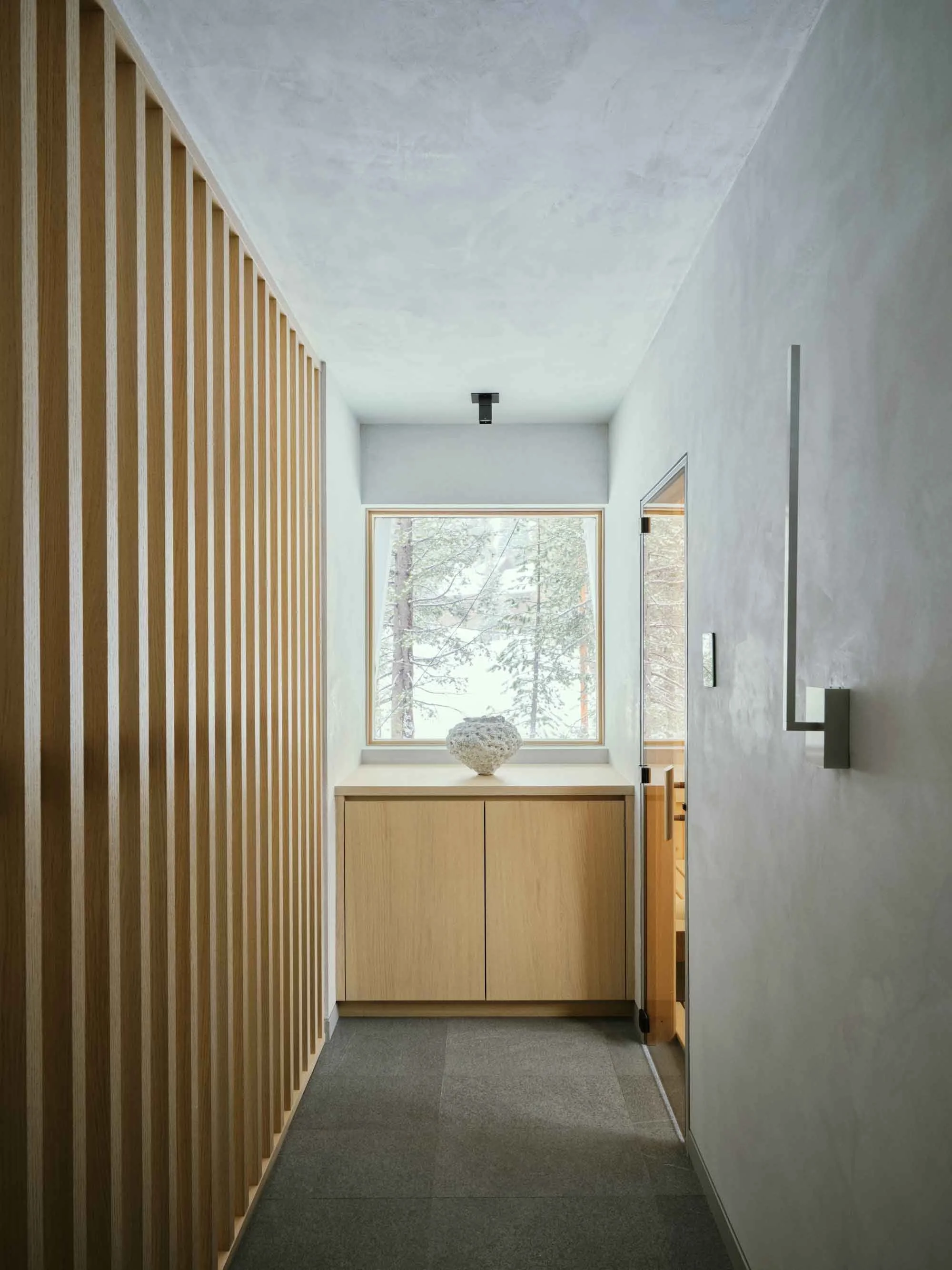 Welcoming mountain home foyer with natural materials, clean lines, and warm minimalist design influenced by European alpine style