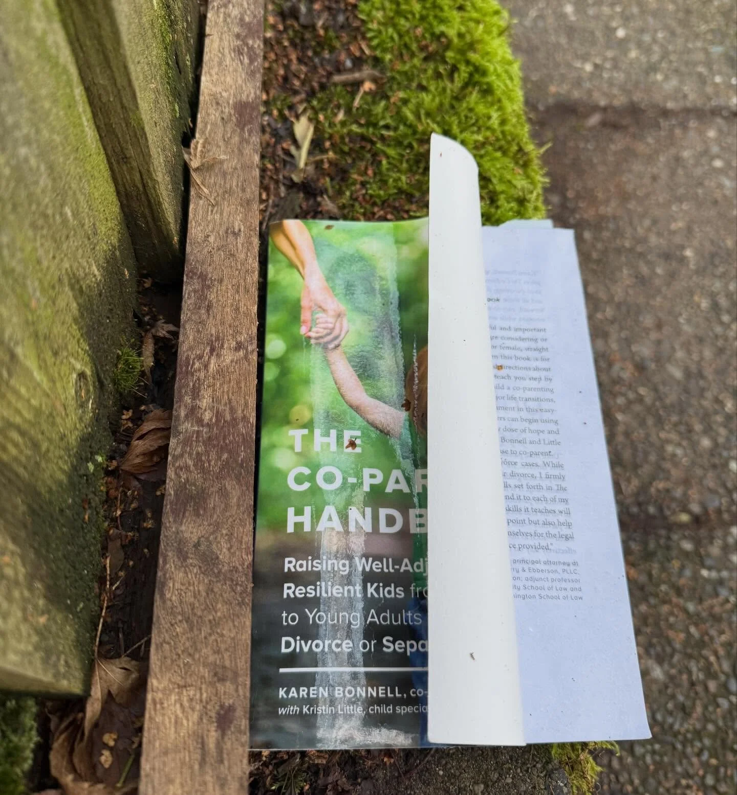 True story: a. couple of months ago I was walking in my neighborhood and came across this copy of The Co-Parenting Handbook by Karen Bonnell and Kristin Little. It was sitting on a ledge on the side of the sidewalk, as if someone sat down to read a b