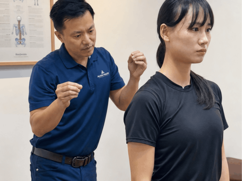 A person receiving a chiropractic adjustment or massage on their upper back by a practitioner.