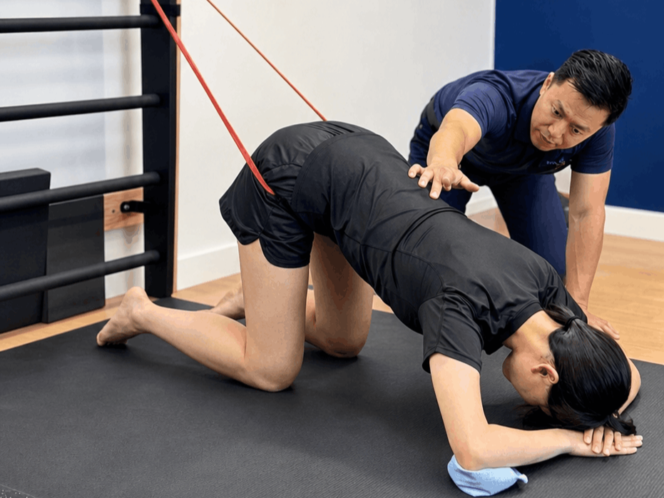 Person stretching with resistance band in a gym.