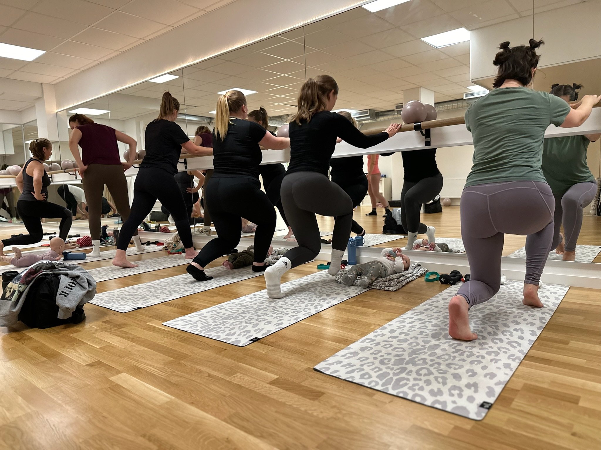 Mammor som engagerar sig i en gruppträning under ett Mama & Baby Bootcamp-pass.