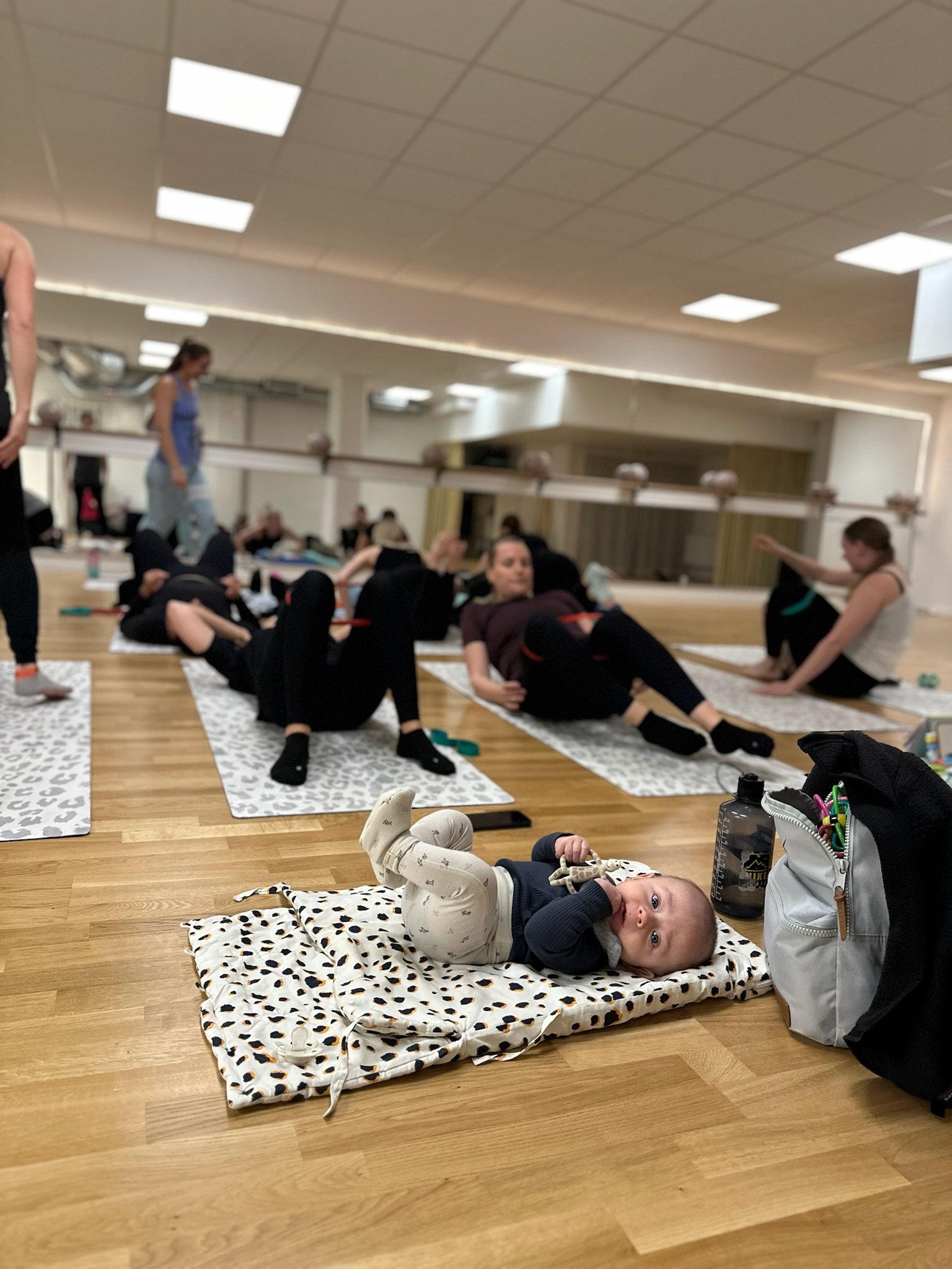 Mammor som tränar tillsammans under ett inspirerande Mama & Baby Bootcamp-pass.