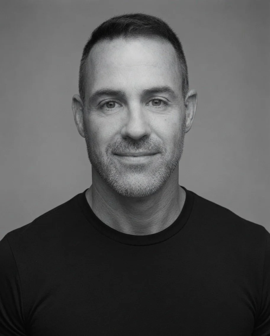 Black-and-white portrait of a man in a suit, smiling slightly.