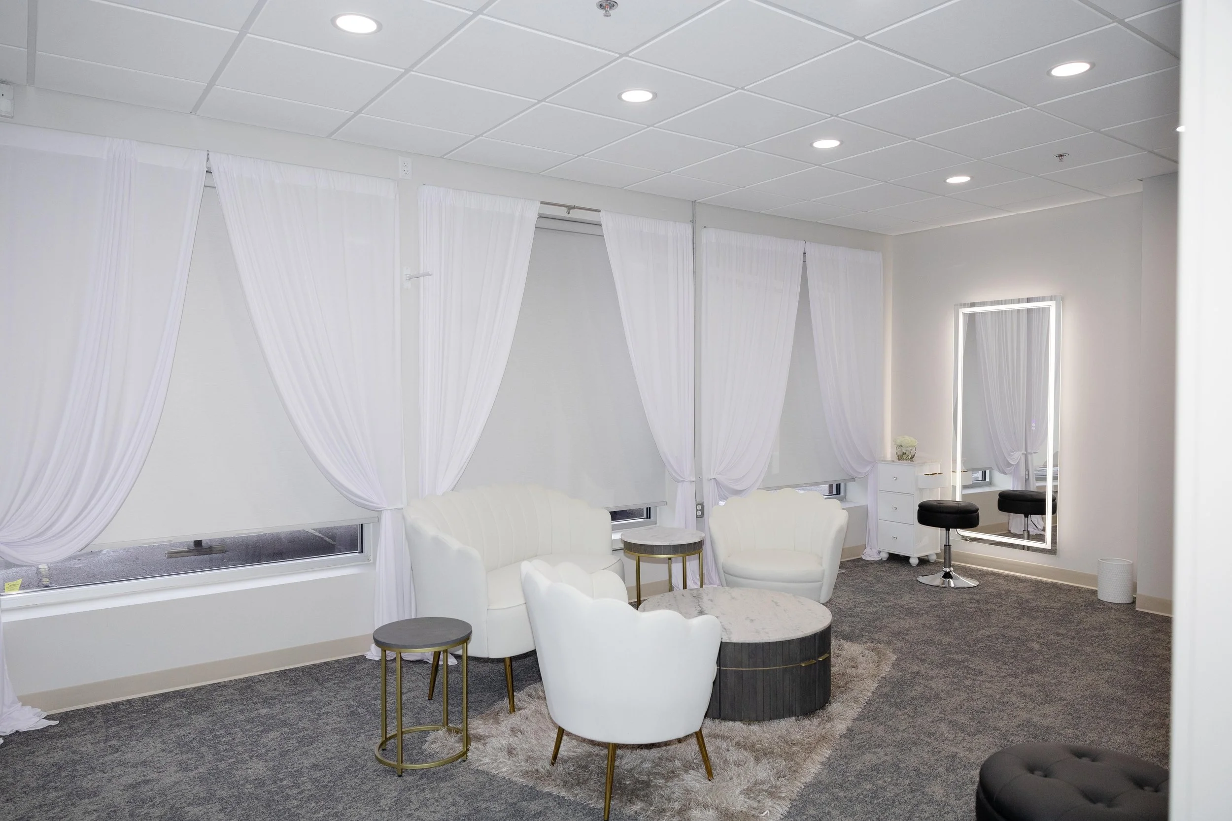 Modern bridal suite sitting area with elegant white drapes and cozy seating at LuxeFalls Venue in Sioux Falls, South Dakota — a relaxing space for brides to get ready in comfort.
