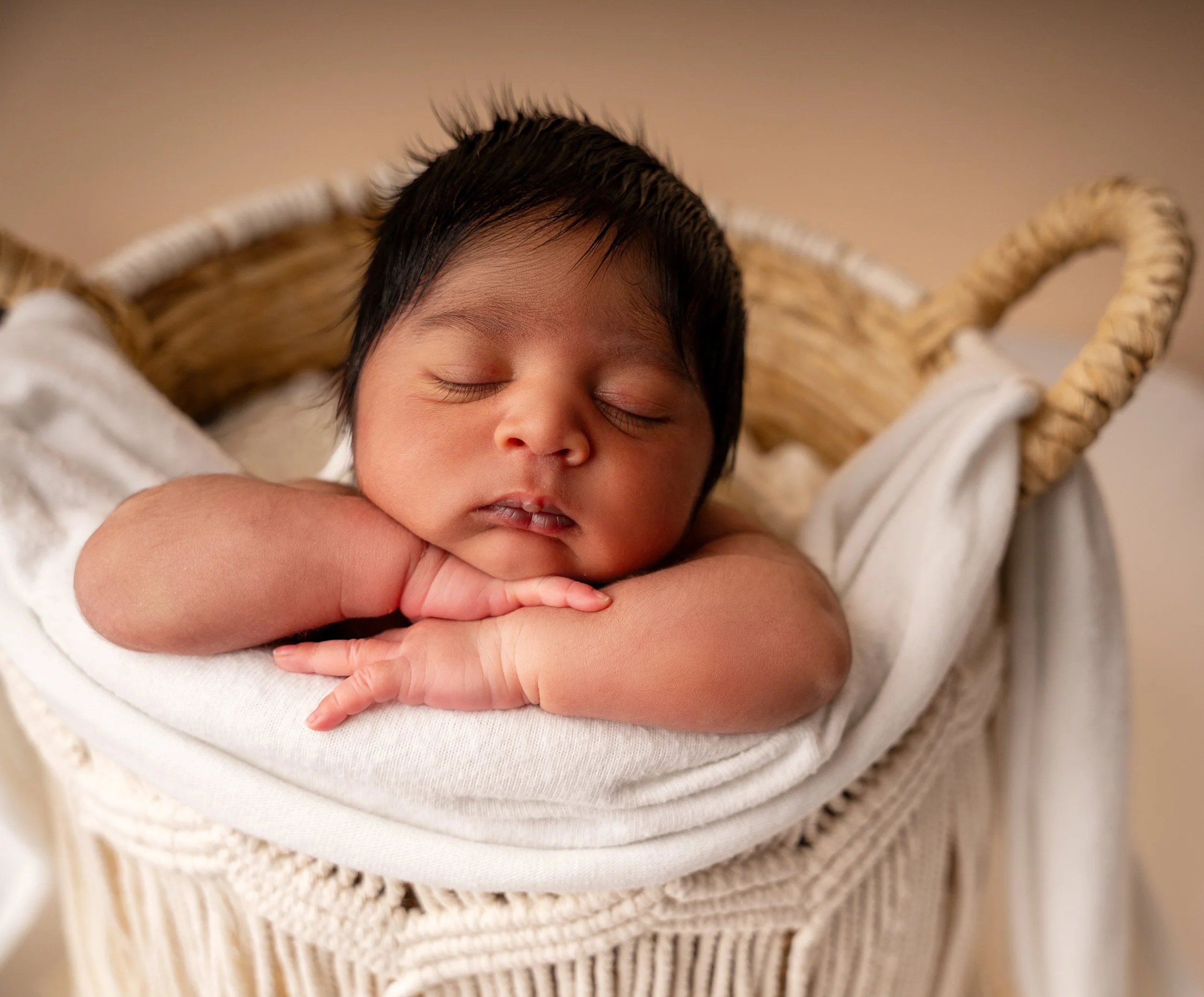newborn posed in basket with head on hands during session with raleigh newborn photographer