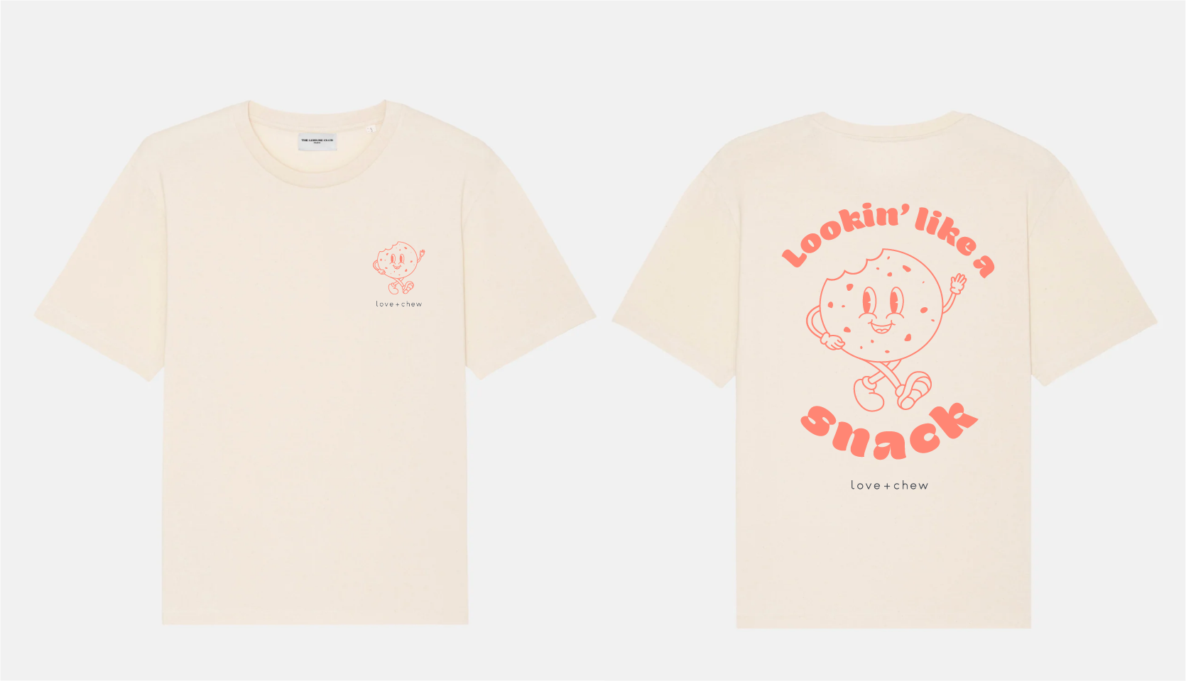 Cream-colored T-shirt with a small cartoon cookie character on the front, and a larger cookie character with the phrase "Lookin’ like a snack" on the back, both in pink line art style.