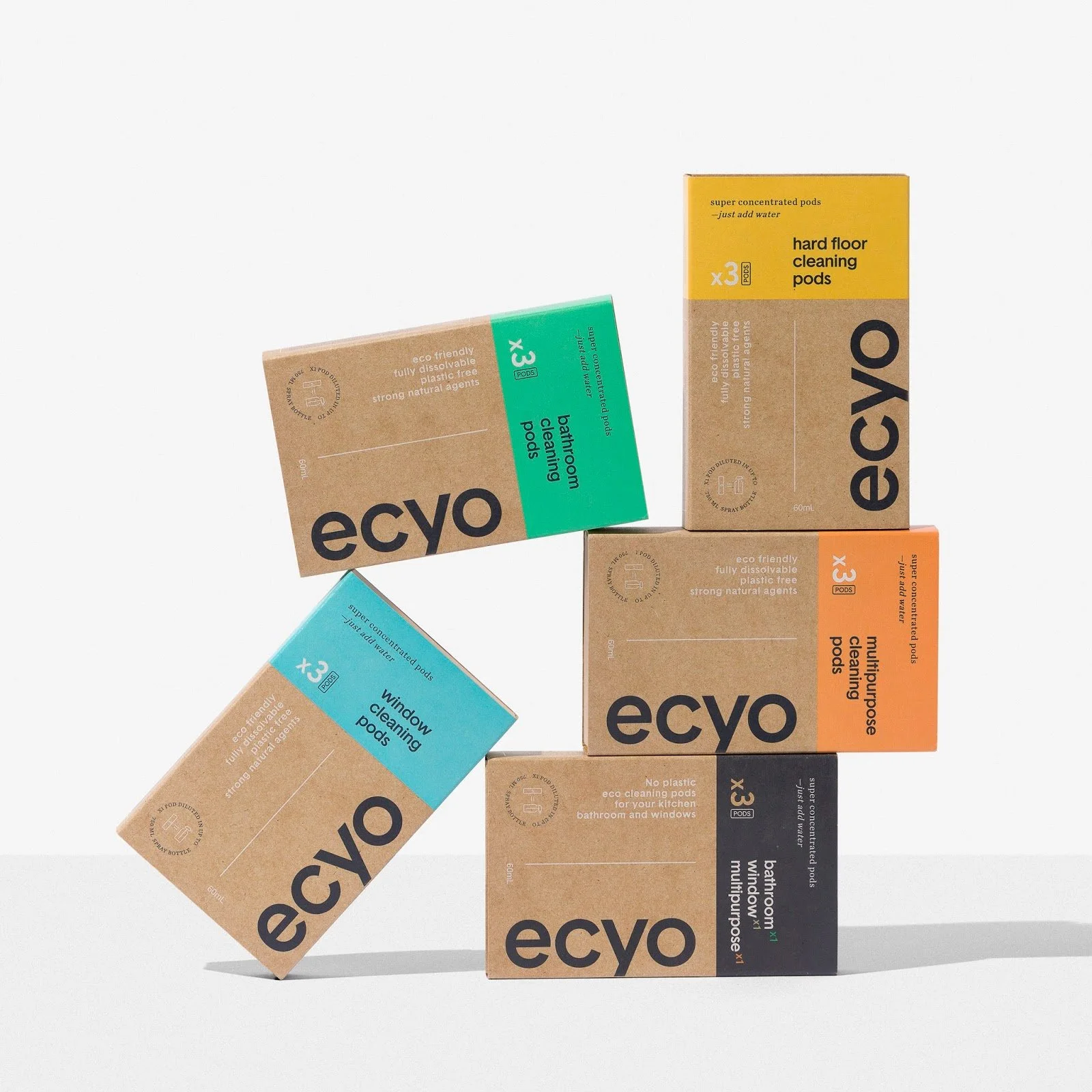 Stacked eco-friendly cleaning product boxes in various colors and labels on a plain white background.