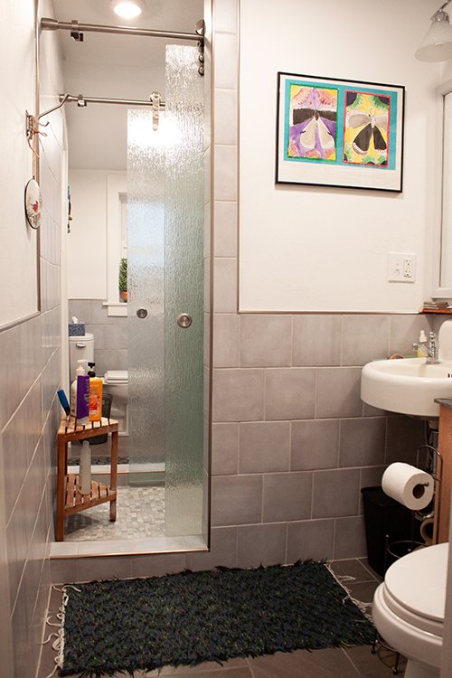 The tiled shower in this home has a double sliding glass door-entry so it can be entered from the bathrooms on either side.
