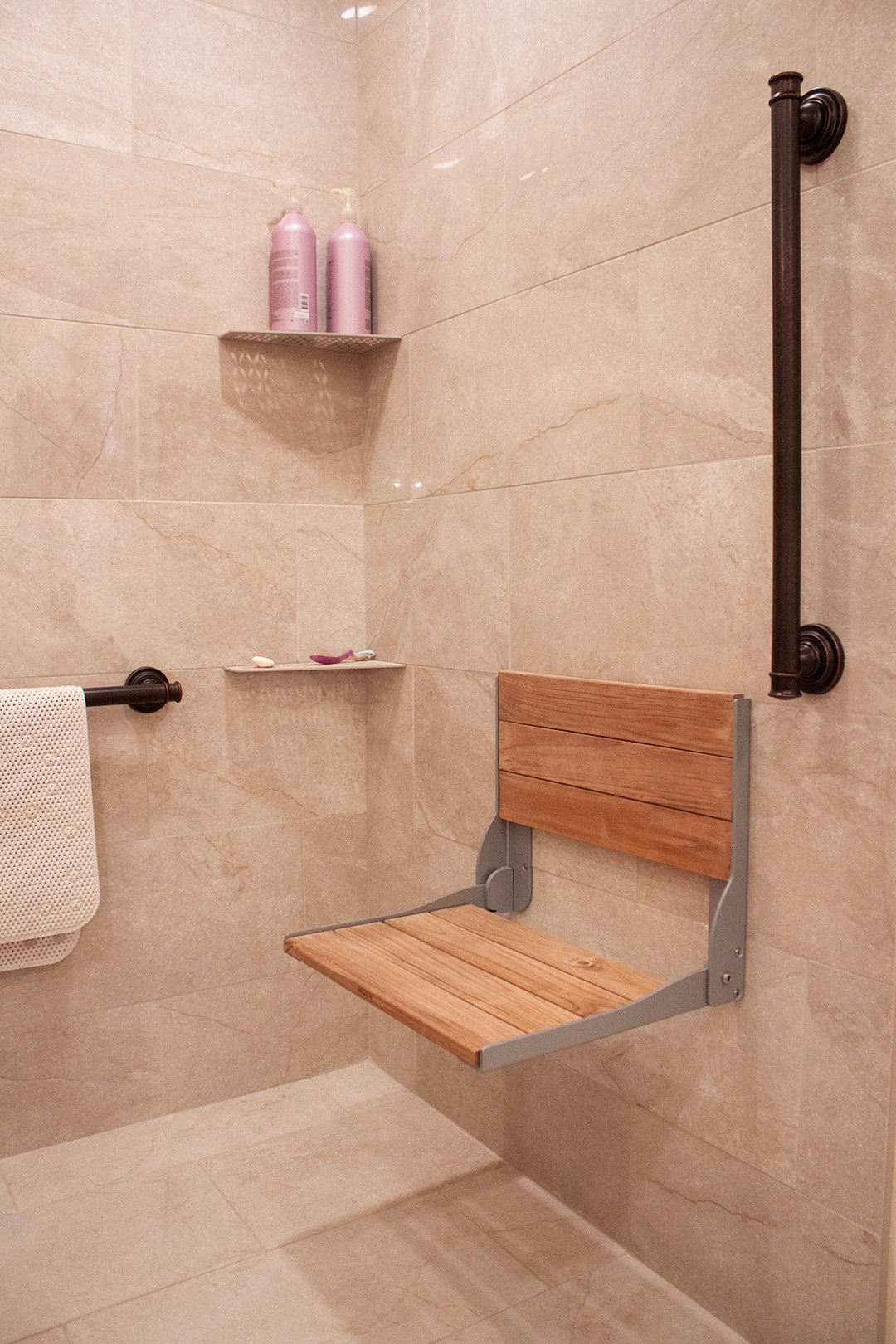 Here is the wood and metal folding chair attached to the shower wall.
